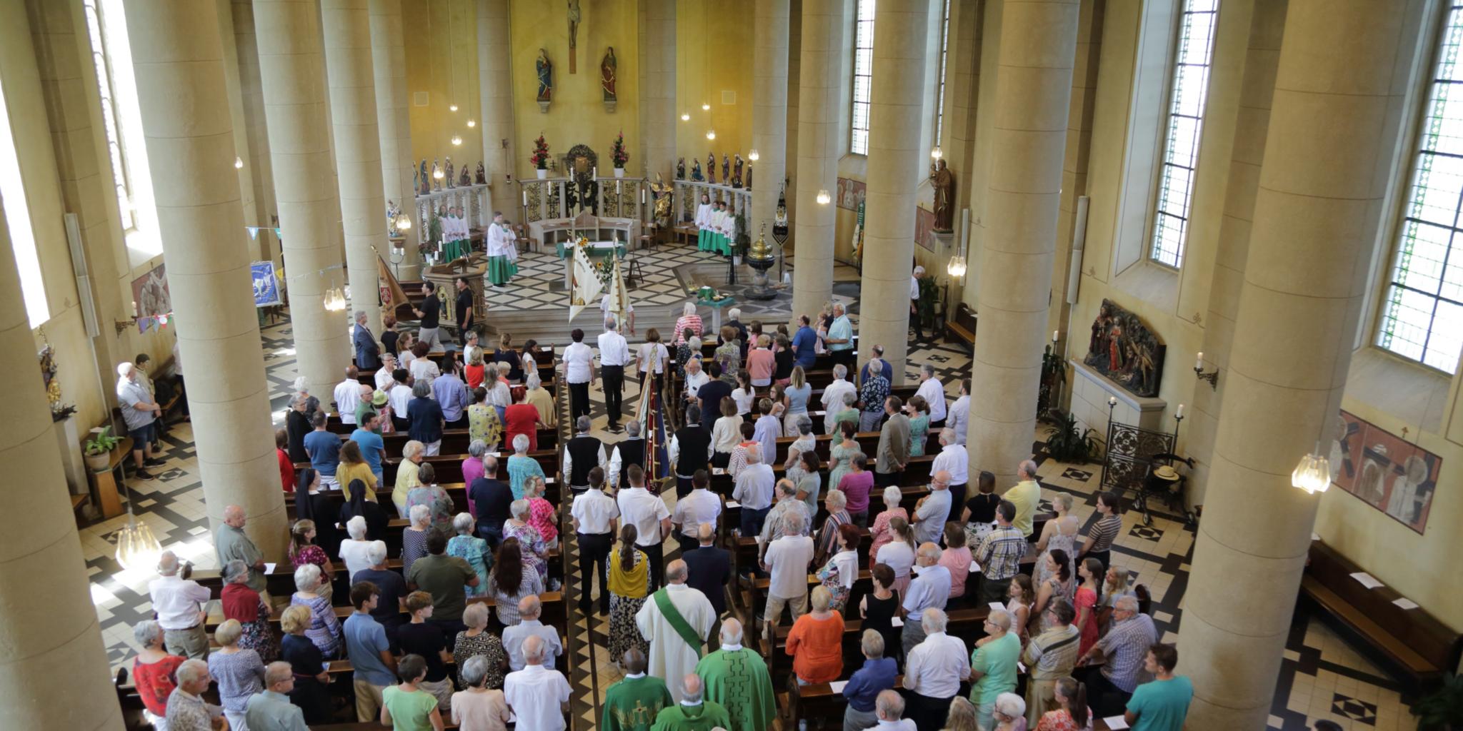 In einer Kirche sind während eines Gottesdienstes alle Plätze von Menschen besetzt