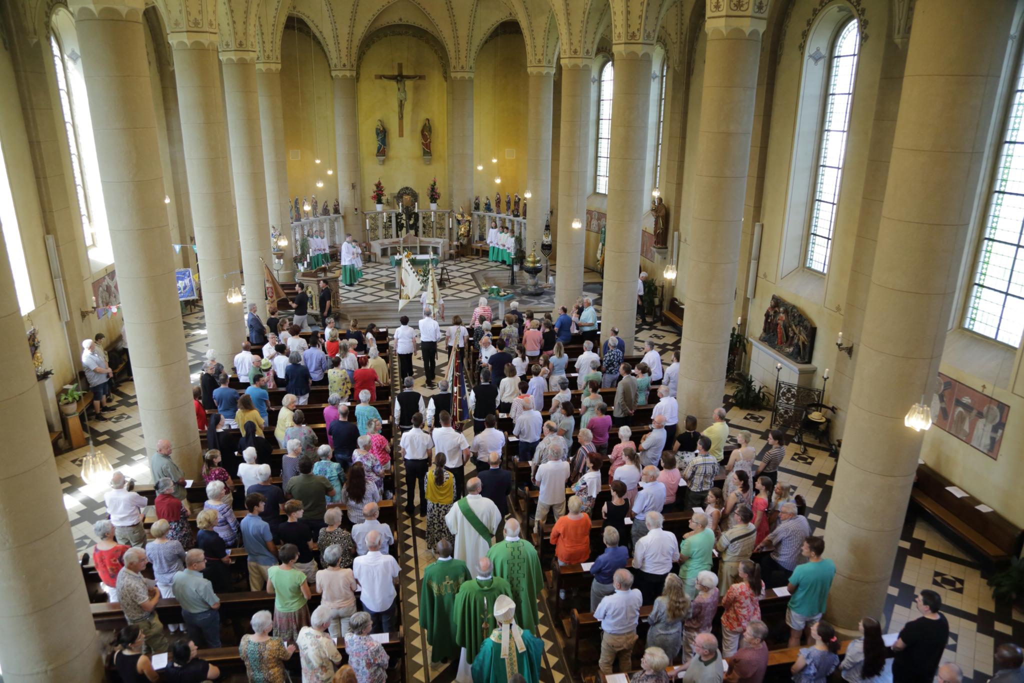 In einer Kirche sind während eines Gottesdienstes alle Plätze von Menschen besetzt