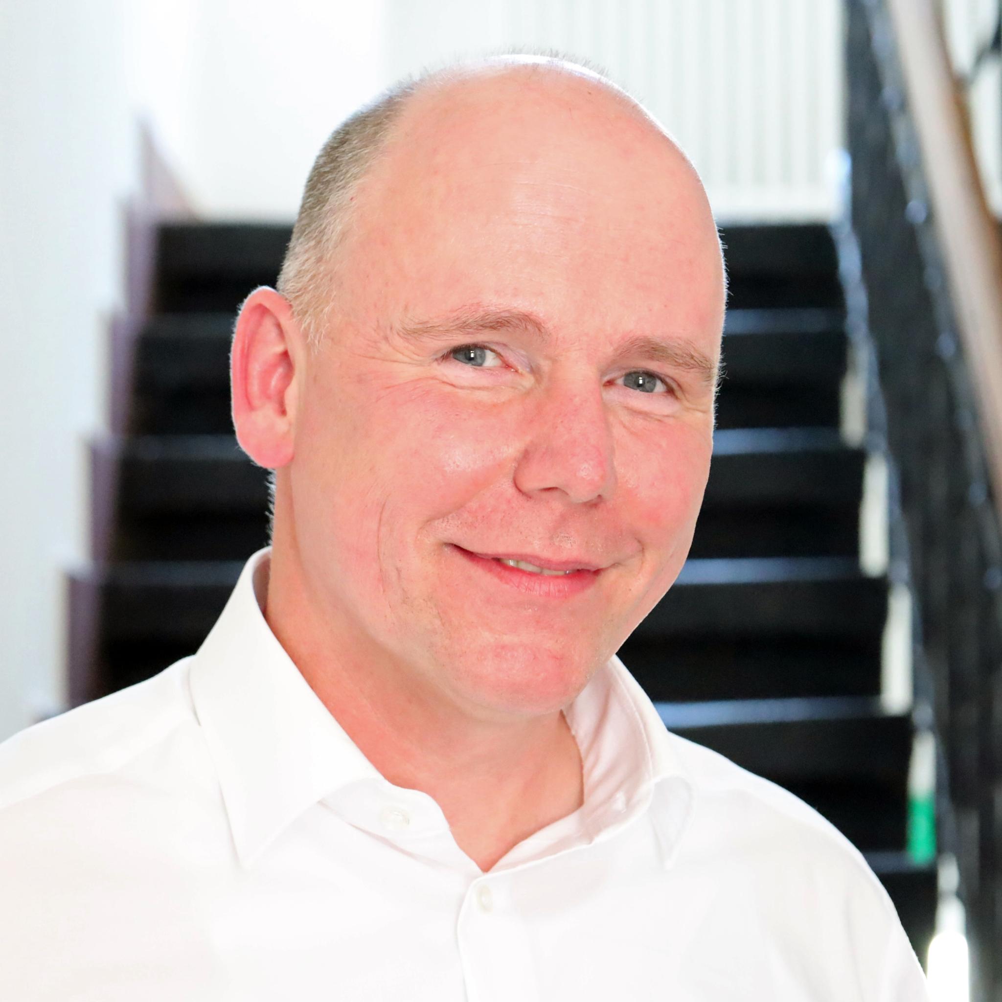 Auf dem Foto zu sehen ist Torsten Wahl vor einer Treppe stehend