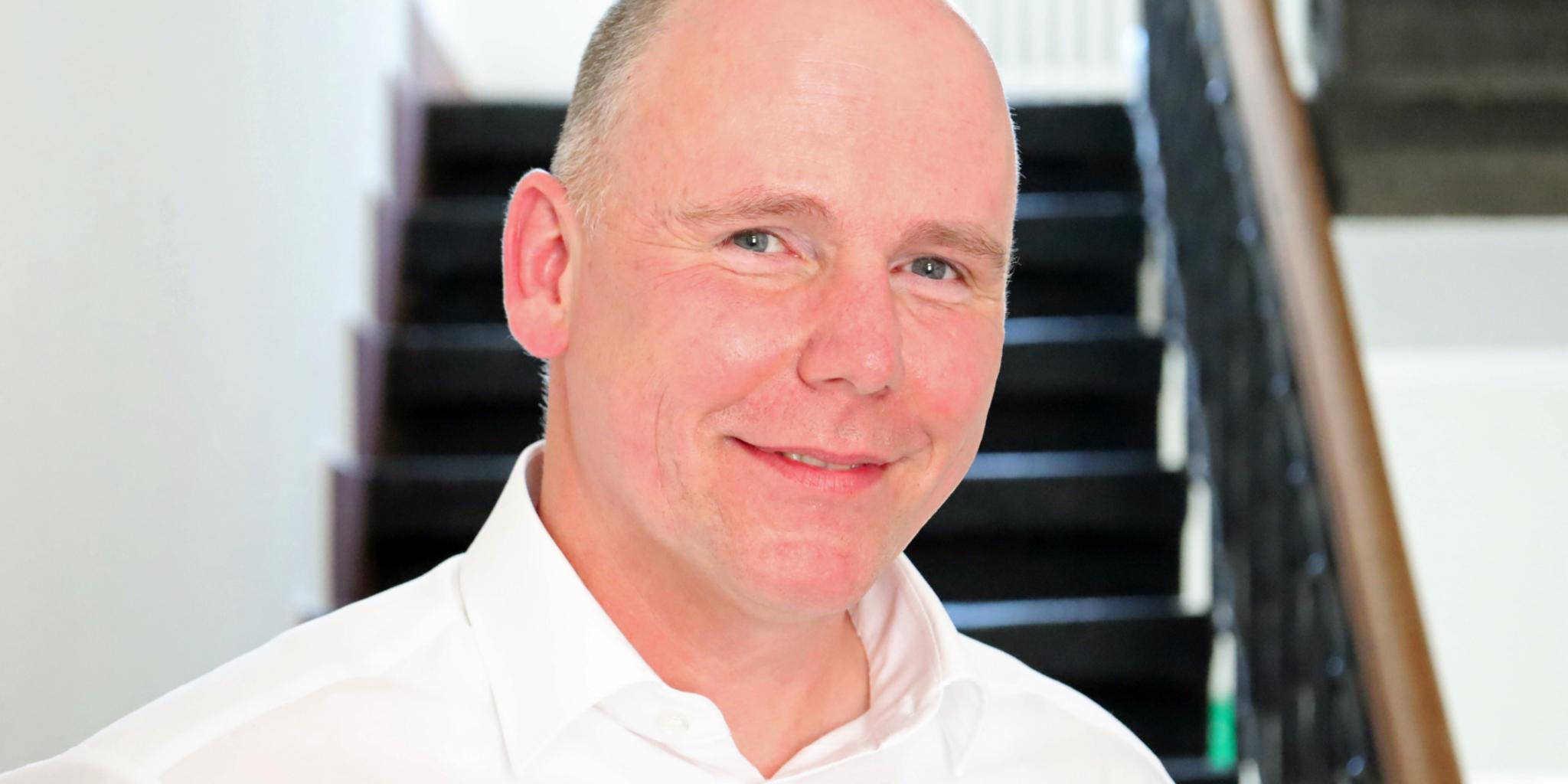 Auf dem Foto zu sehen ist Torsten Wahl vor einer Treppe stehend