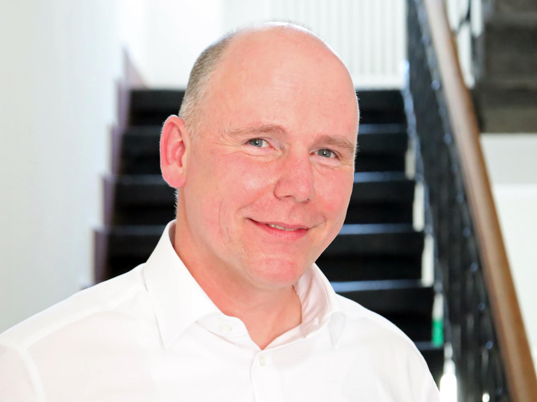 Auf dem Foto zu sehen ist Torsten Wahl vor einer Treppe stehend