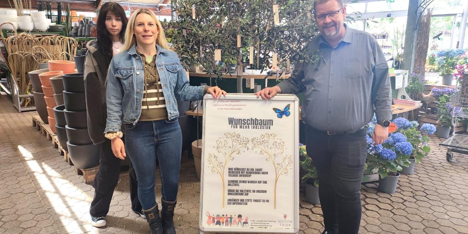 Die Tonpost im Gartenzentrum: Emily Reimann, FSJlerin in der Tonpost, Kathrin Schmitt, Leiterin der Tonpost und Martin Oed, Geschäftsführer Lambert, haben mit dem Wunschbaum ein Zeichen für mehr Inklusion gesetzt.