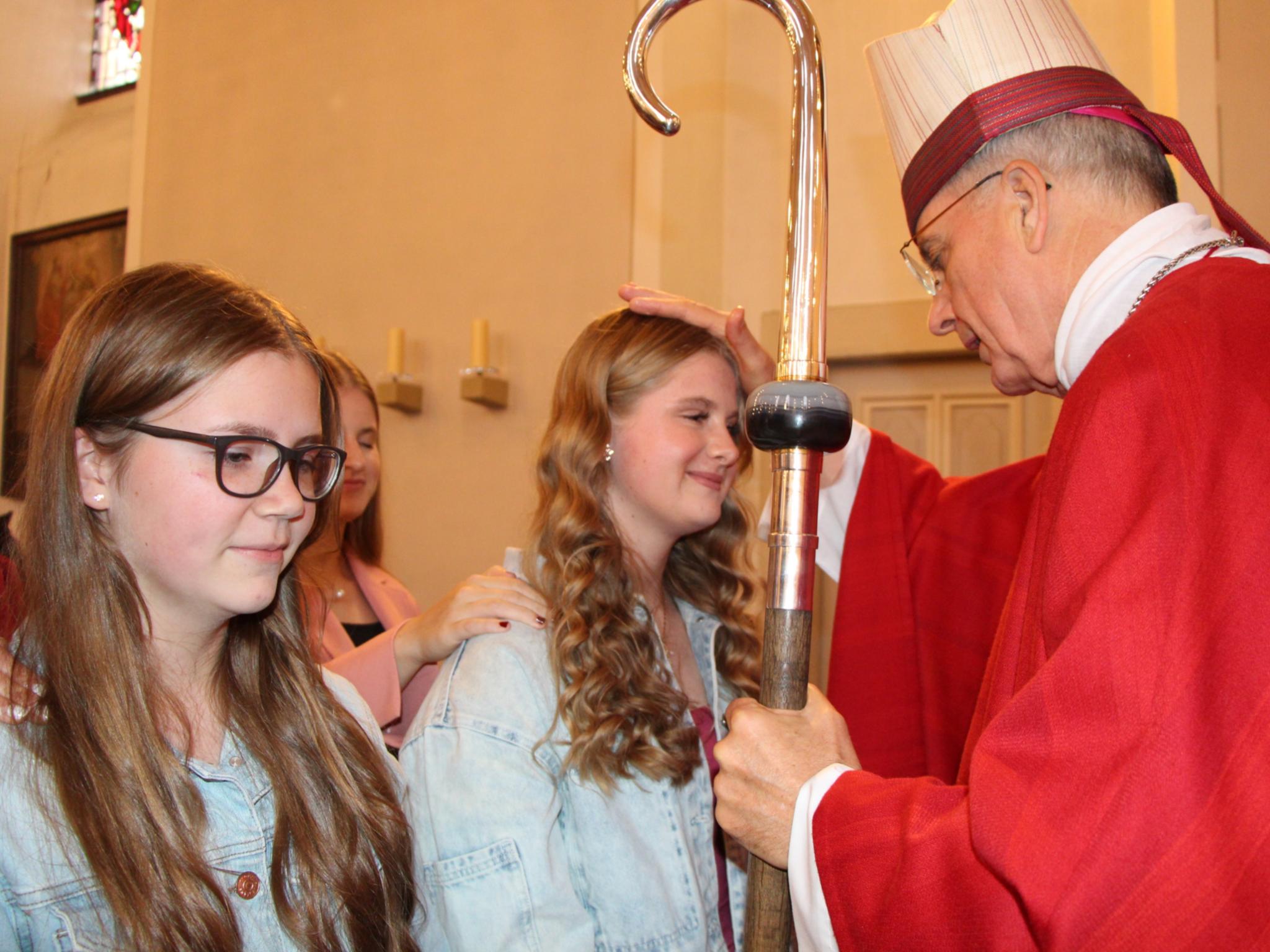 Weihbischof Peters spendet einer jungen Christin das Firmsakrament.