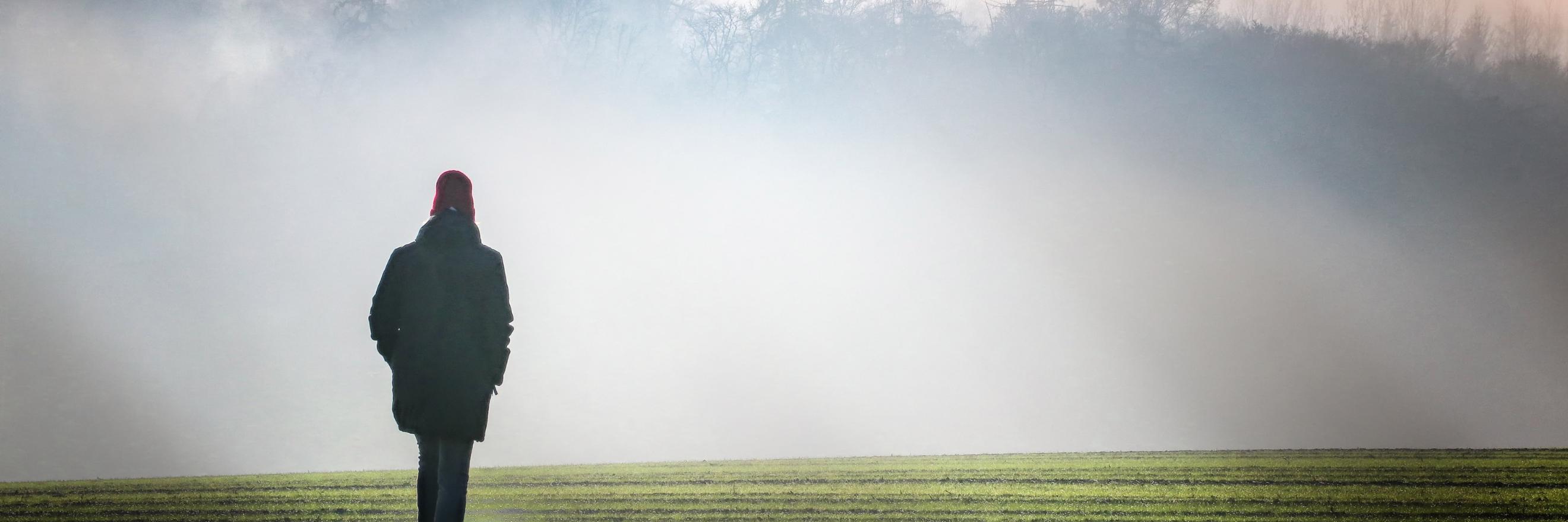 Eine Person geht im Nebel spazieren