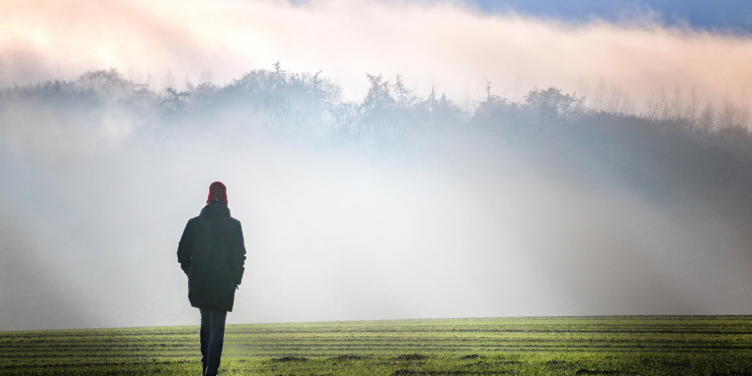 Eine Person geht im Nebel spazieren