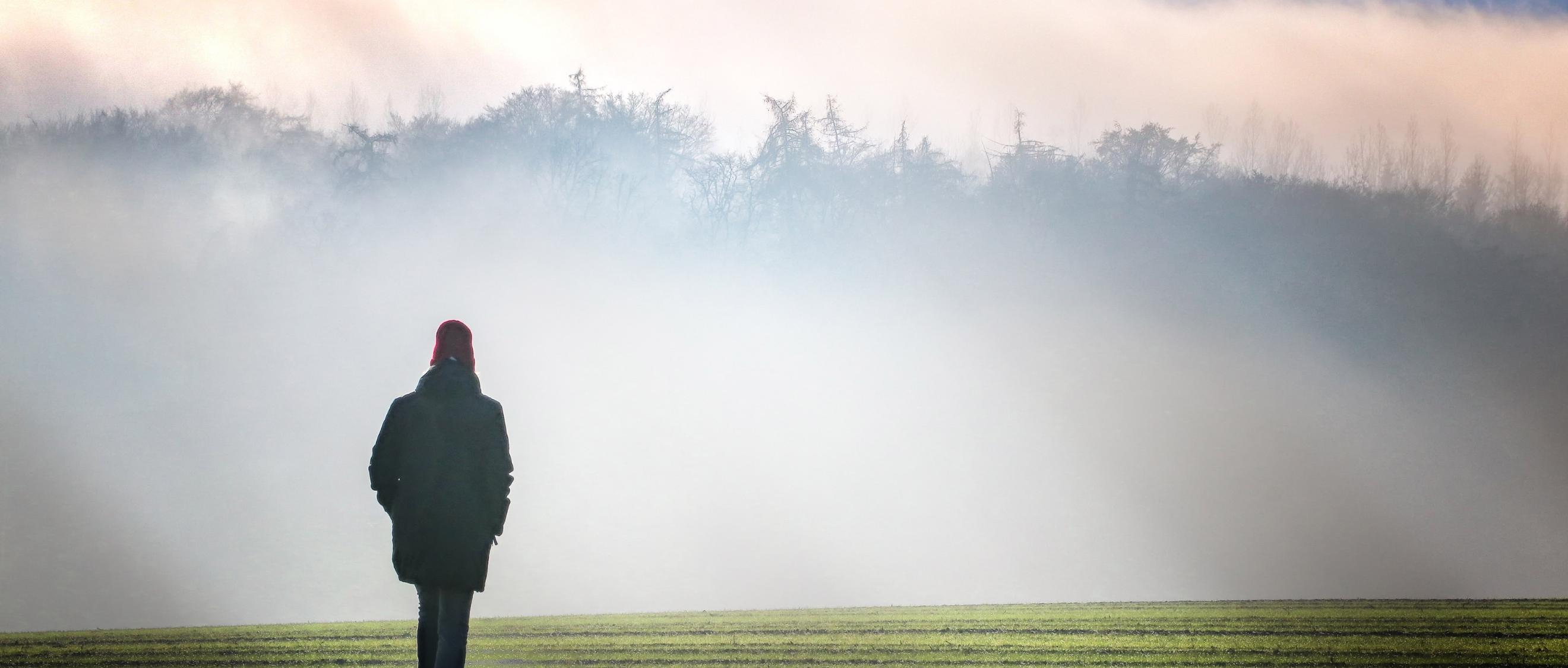 Eine Person geht im Nebel spazieren