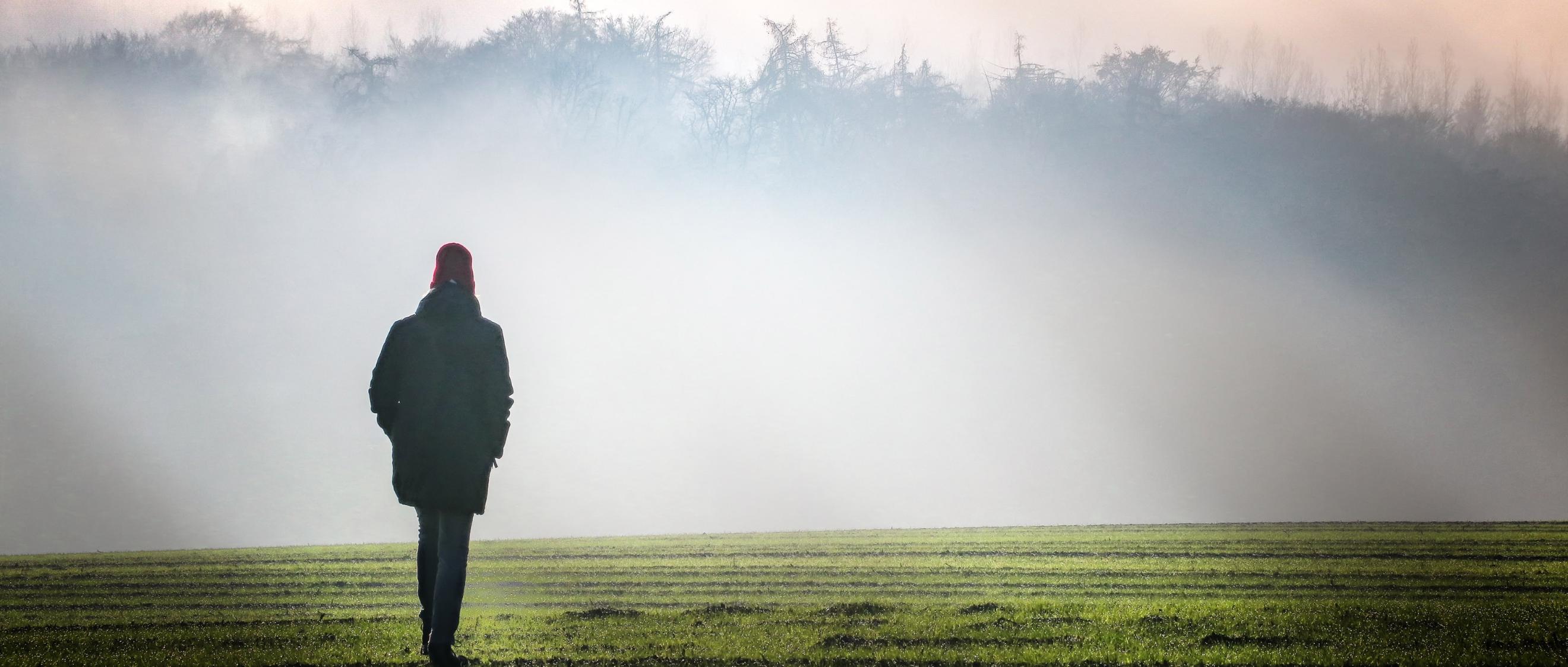 Eine Person geht im Nebel spazieren