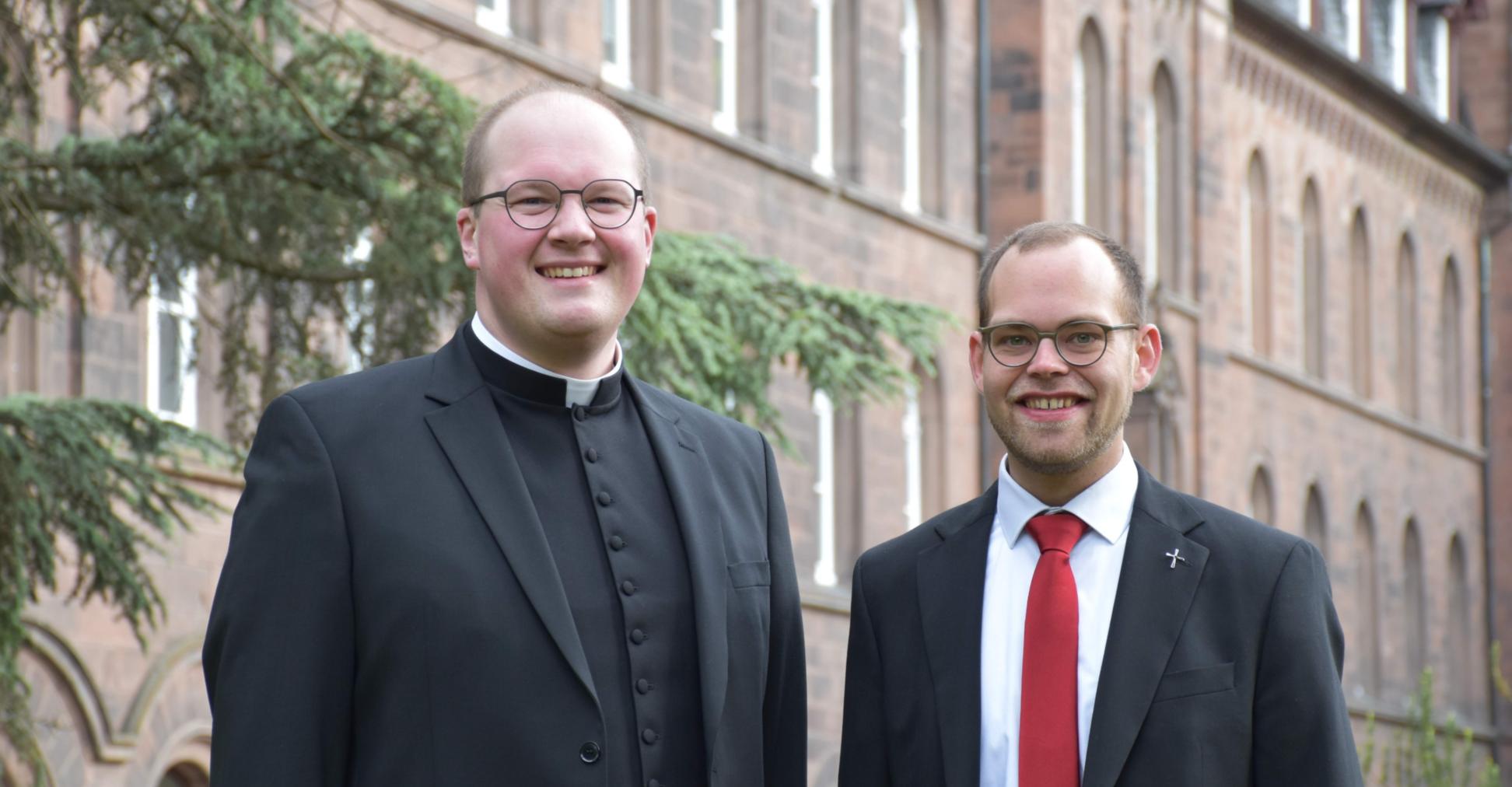 Die beiden Diakone stehen vor dem Gebäude des Priesterseminars