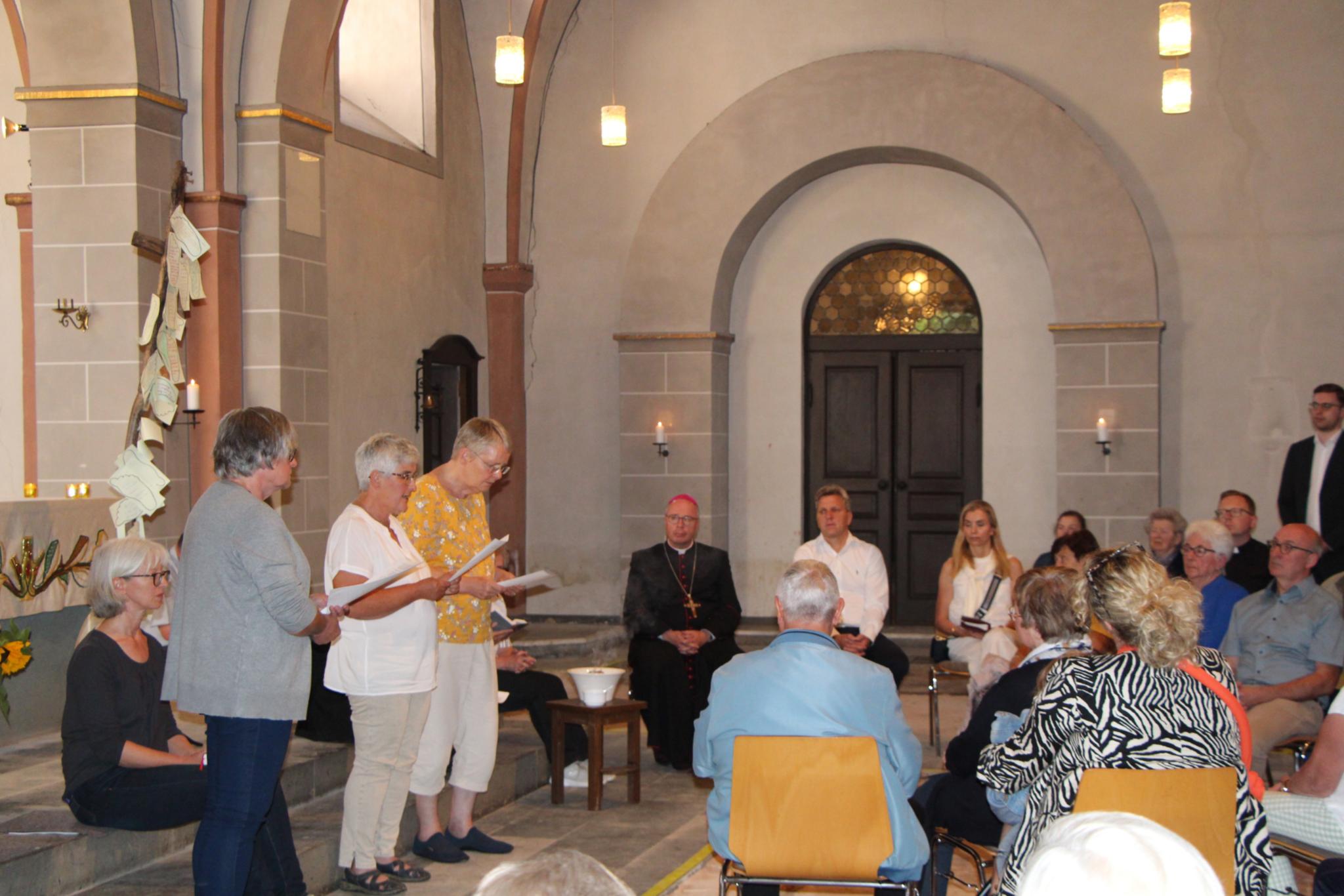 Frauen aus dem Vorbereitungsteam um Gemeindereferentin Anette Weber (links sitzend) tragen in der St. Luzia-Pfarrkirche Mürlenbach bei der Gedenkfeier mit Bischof Ackermann am zweiten Jahrestag der Flutkatastrophe Texte vor