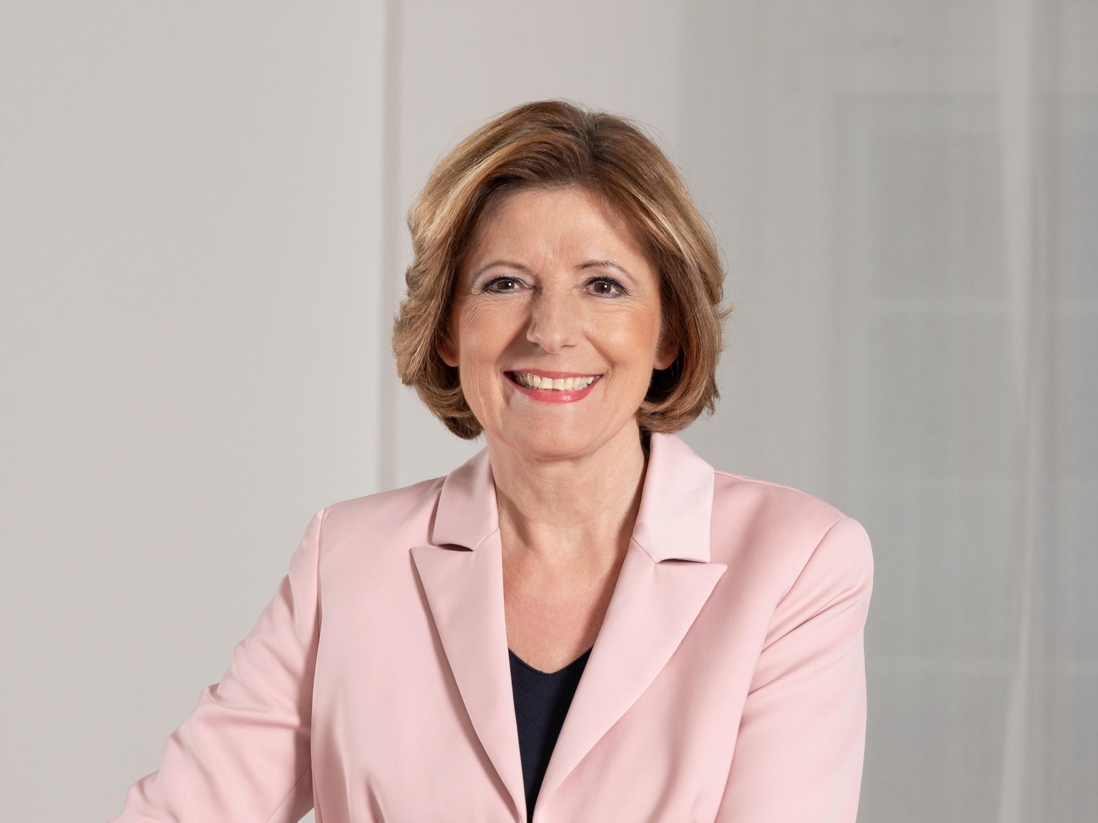 Malu Dreyer im rosa Blazer lächelt freundlich in die Kamera. (KI-Text)