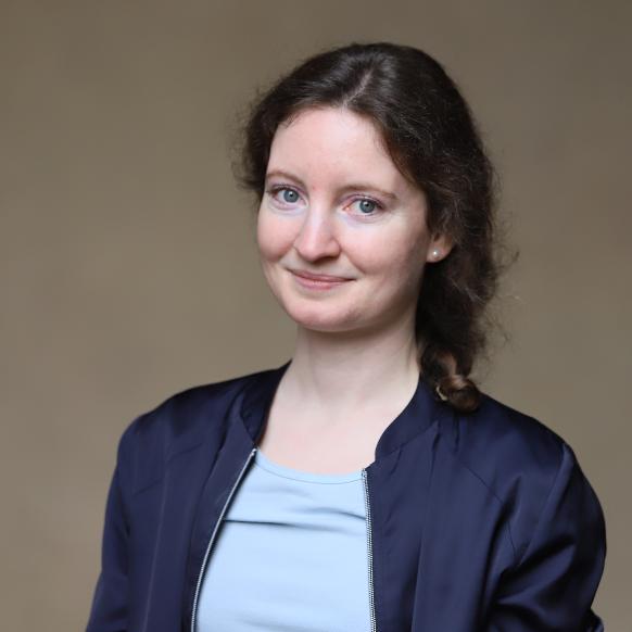 Man sieht eine junge Frau mit Locken, die im Nacken zusammen genommen wurden. Sie lächelt in die Kamera (c) Bistum Trier, Constanze Haubrich Man sieht eine junge Frau mit Locken, die im Nacken zusammen genommen wurden. Sie lächelt in die Kamera