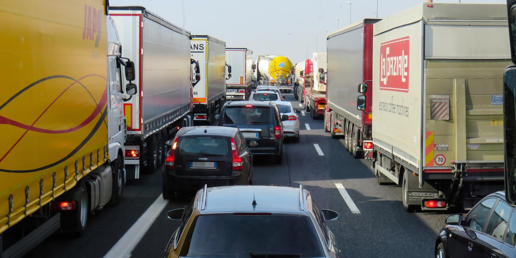 PKWs und LKWs stehen auf einer Autobahn im Stau