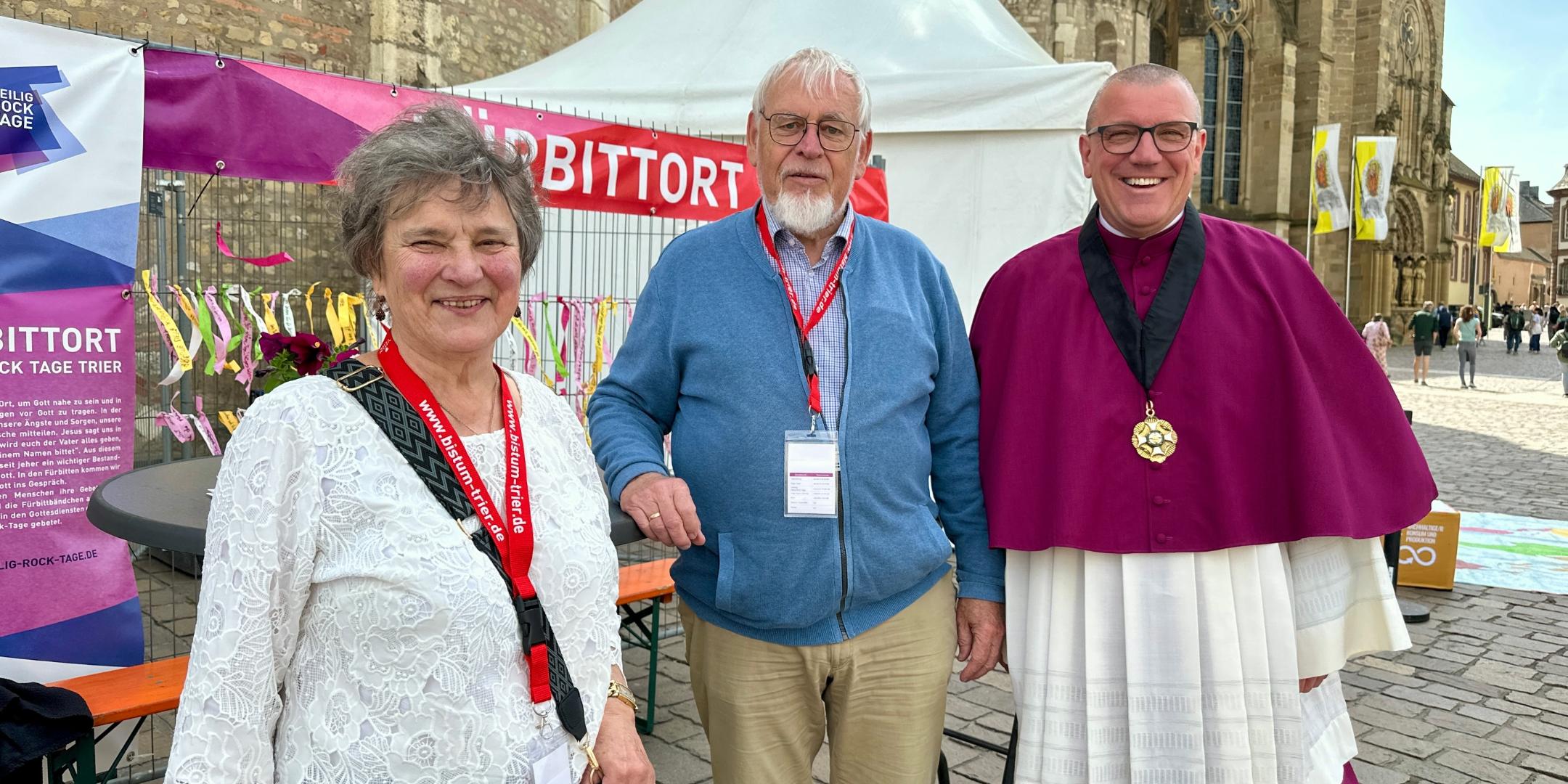 Drei ältere Menschen stehen vor dem Dom