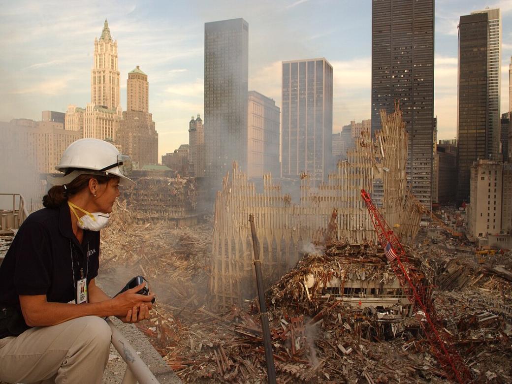 Eine Frau sitzt vor den Trümmern des World Trade Centers