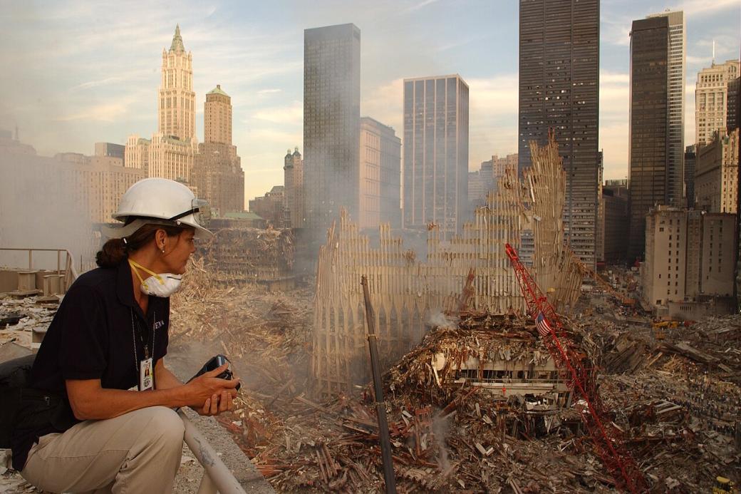 Eine Frau sitzt vor den Trümmern des World Trade Centers