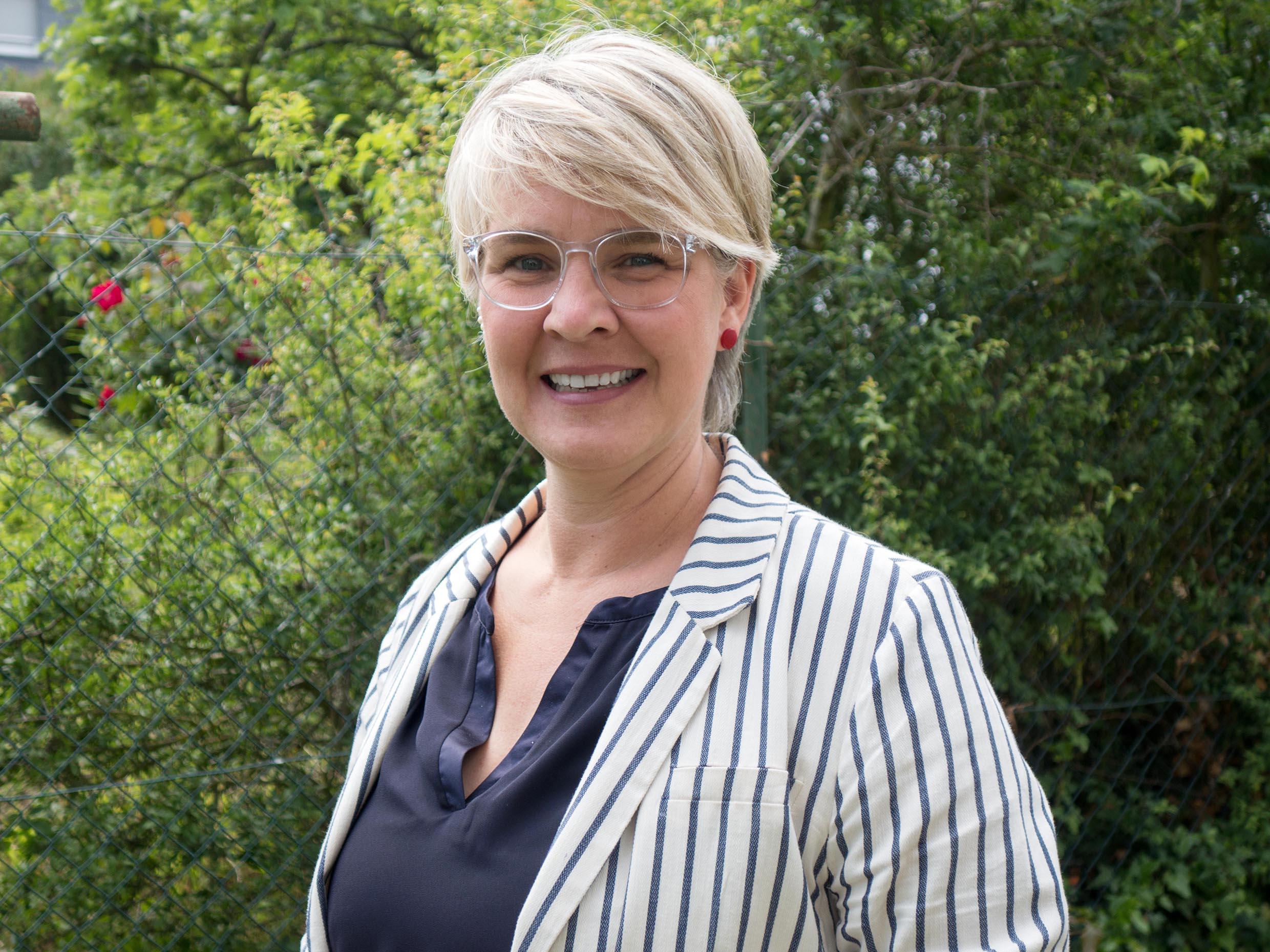 Portraitfoto einer Frau mit Brille und kurzen Haaren