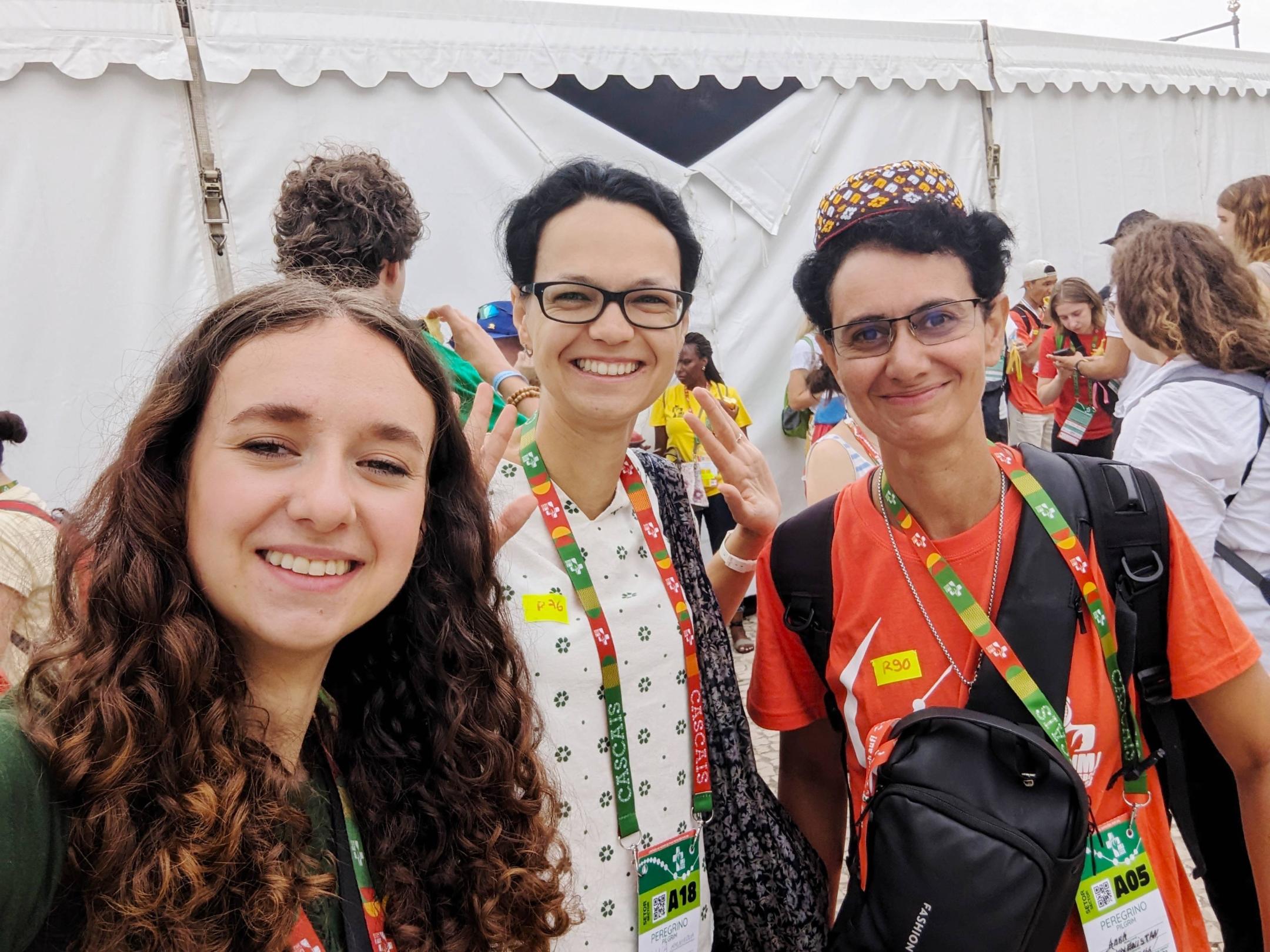 Ella Schmitt (links) bereitet sich gemeinsam mit Vertreter*innen anderer Länder im Zelt auf das Fahnen-Schwenken vor.