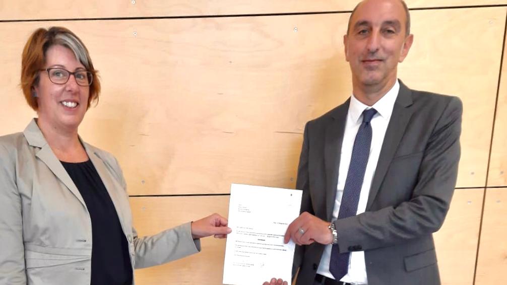 Dr. Kerstin Schmitz-Stuhlträger mit Patric Busch und Ernennungsurkunde des Generalvikars