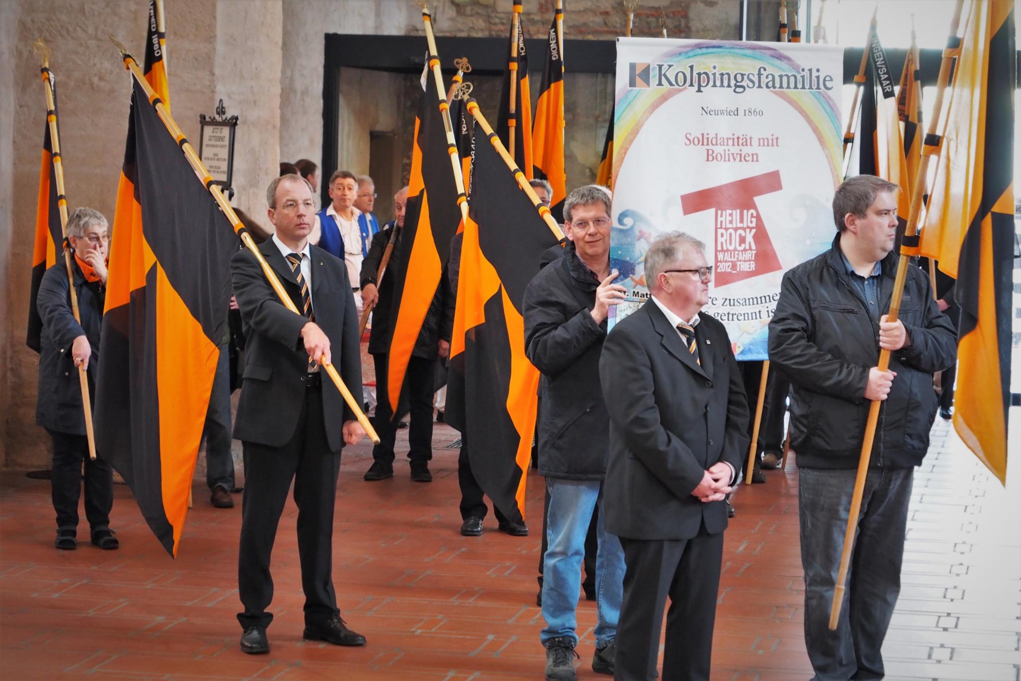 Menscen mit orange/schwarzen Flaggen bei der Wallfahrt der Kolpingsfamilie zum Trierer Dom