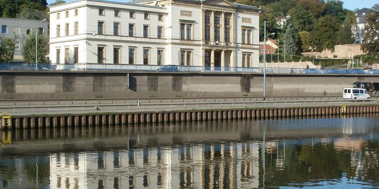 großes, weißes Gebäude an Fluss