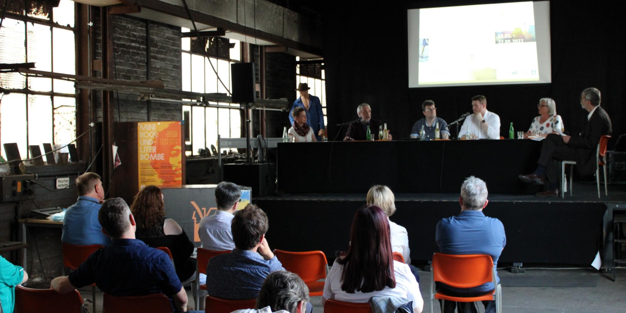Rustikale Atmosphäre in der gut besuchten Dudweiler Kulturfabrik. Auf dem Podium (v.l.) Ulrike Laux, Dr. Andreas Zimmer, Ralf-Peter Fritz, Tobias Raab, Ulrike Zuda-Tietjen und Moderator Wolfgang Drießen, Foto: evks/Eulenstein