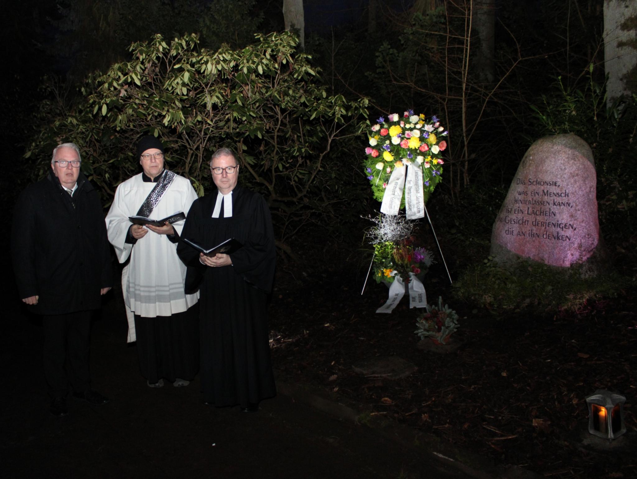 Christian Duchene, Diakon Fehrenbach und Superintendent Weyer neben dem Gedenkstein unweit des Eingangs zum Saarbrücker Hauptfriedhof Foto: evks/Rieke Eulenstein