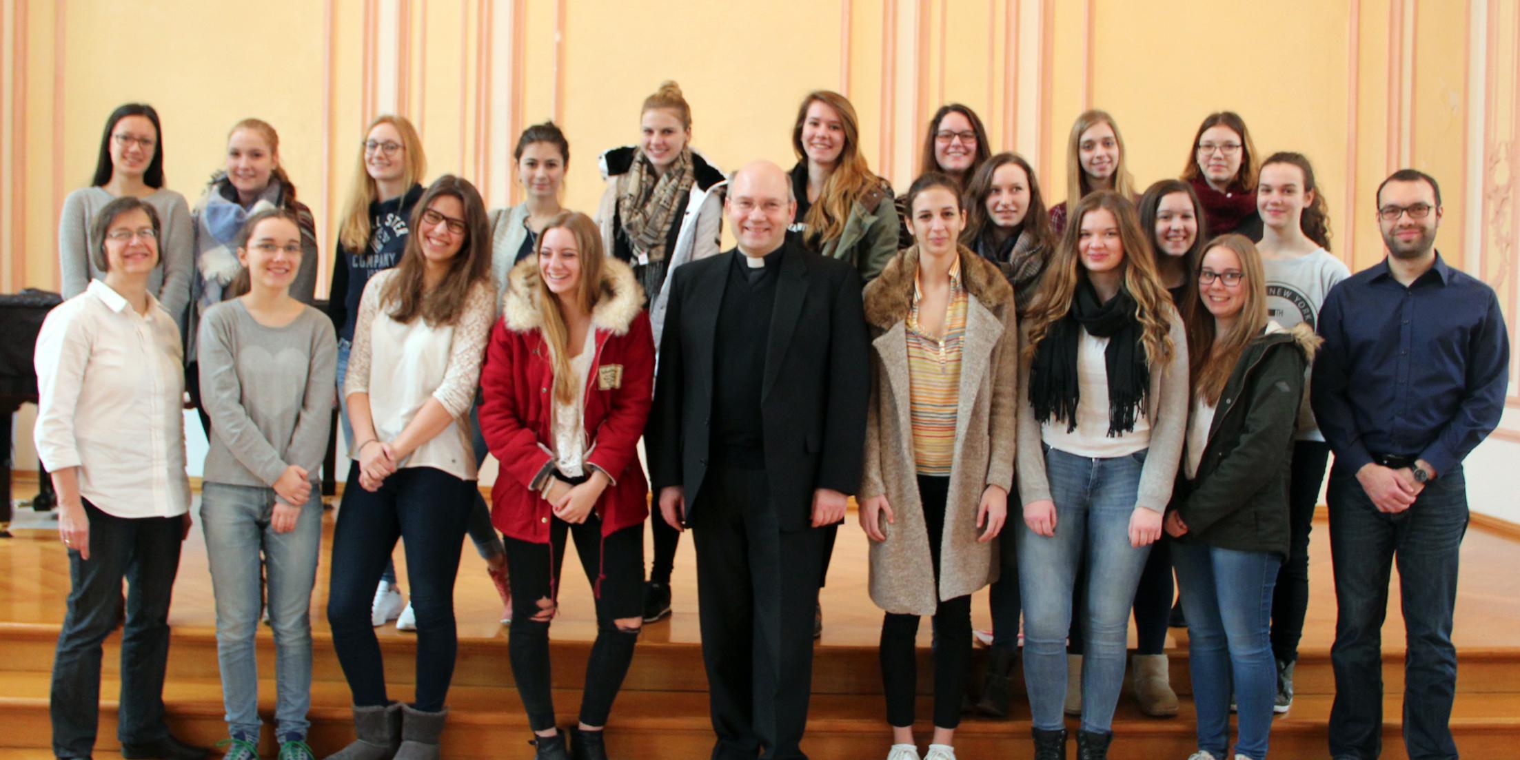 Die Klasse 11a mit Weihbischof Dr. Dieser (mitte), Religionslehrerin Gisela Still (links) und Referendar Bernhard Luithle (rechts).