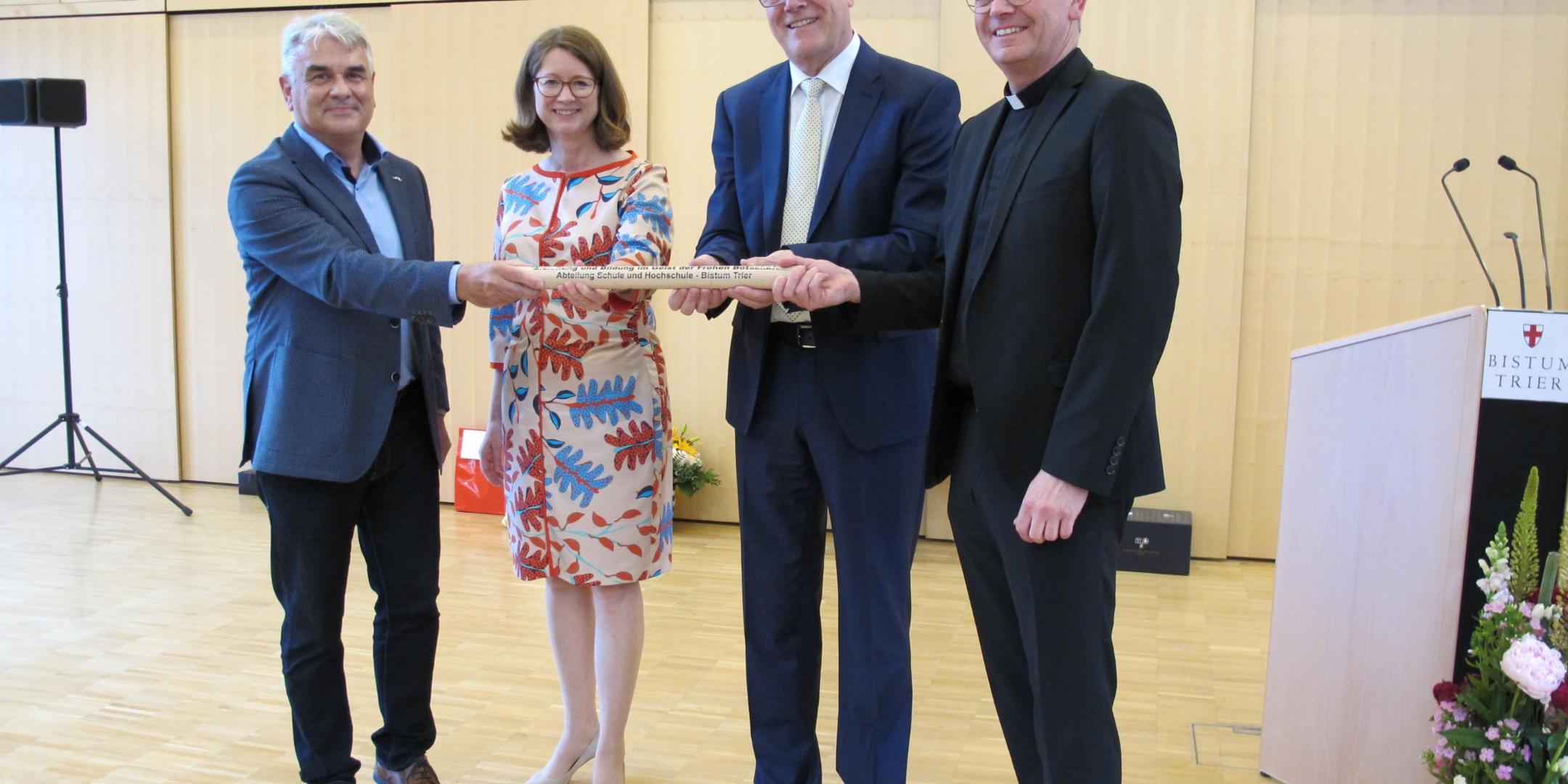 Albrecht Adam, Direktorin Mechthild Schabo, Wolfgang Müller und Generalvikar Dr. Ulrich Graf von Plettenberg (vlnr.) bei Übergabe des 'Staffel-Stabes' der Schulabteilung an Adam