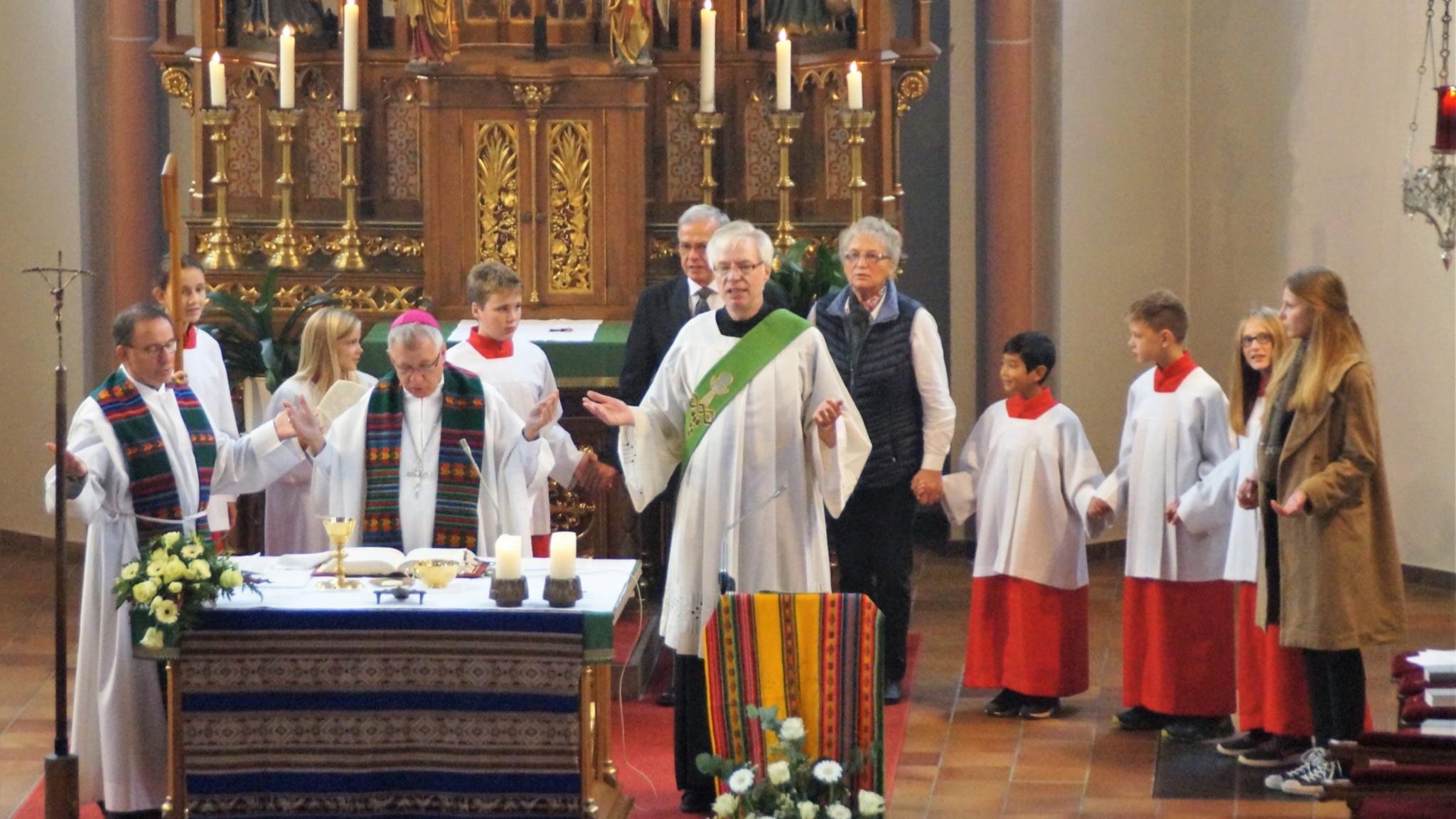 Eingerahmt von Pfarrer Jonas Weber und Diakon Herbert Knobloch betet Bischof Flock mit der Gemeinde das Vaterunser.