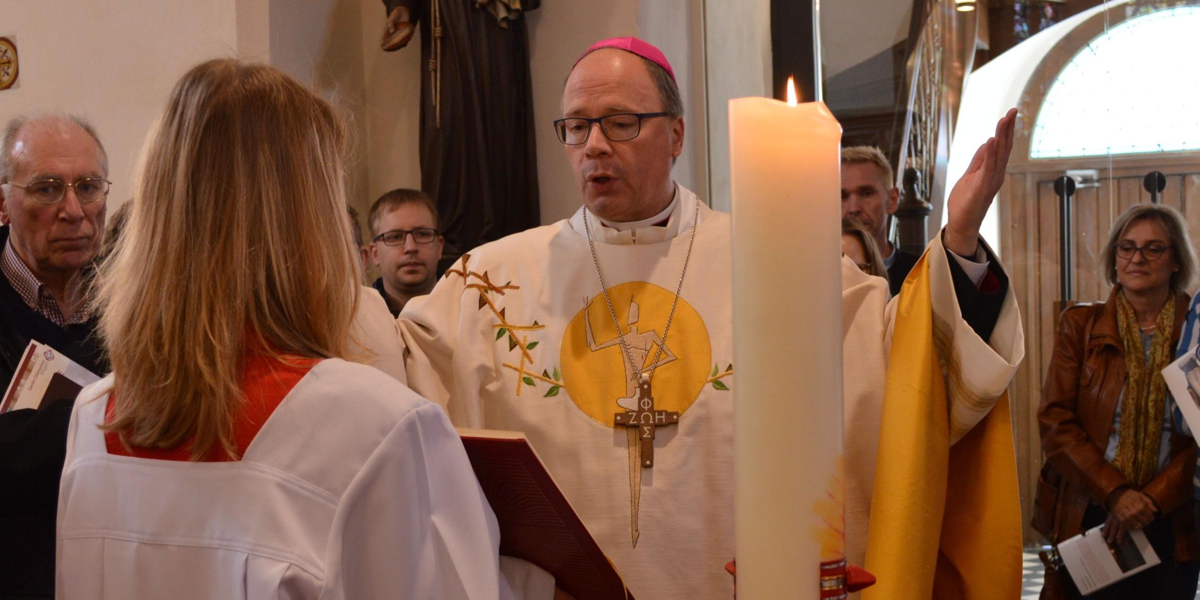 Bischof Ackermann am Taufbecken der Pfarrkirche Bischof Ackermann spricht ein Gebet vor dem Taufbecken der Pfarrkirche