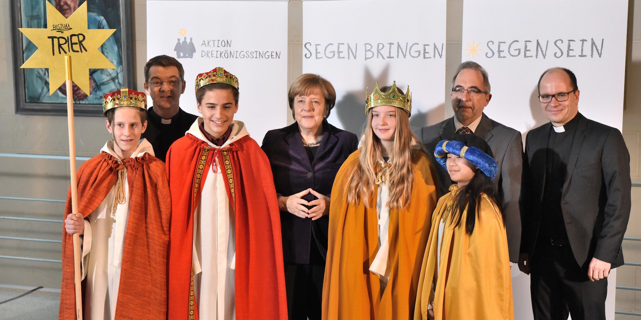 Die Sternsinger Ann-Kathrin Michel (13), Johannes Wiedemann (13), Johannes Jüngling (14) und Serena Chang (12) sowie Begleiter Andreas Michel aus der Gemeinde St. Nikolaus in Traben-Trarbach vertraten das Bistum Trier am Dienstagmorgen beim Sternsinger-Empfang von Bundeskanzlerin Angela Merkel zur 58. Aktion Dreikönigssingen. Zum Gruppenfoto mit der Kanzlerin stellten sie sich gemeinsam mit Prälat Dr. Klaus Krämer, Präsident des Kindermissionswerks „Die Sternsinger“, und Pfr. Dirk Bingener, Bundespräses des Bundes der Deutschen Katholischen Jugend (BDKJ), im Bundeskanzleramt auf. Foto: Ralf Adloff