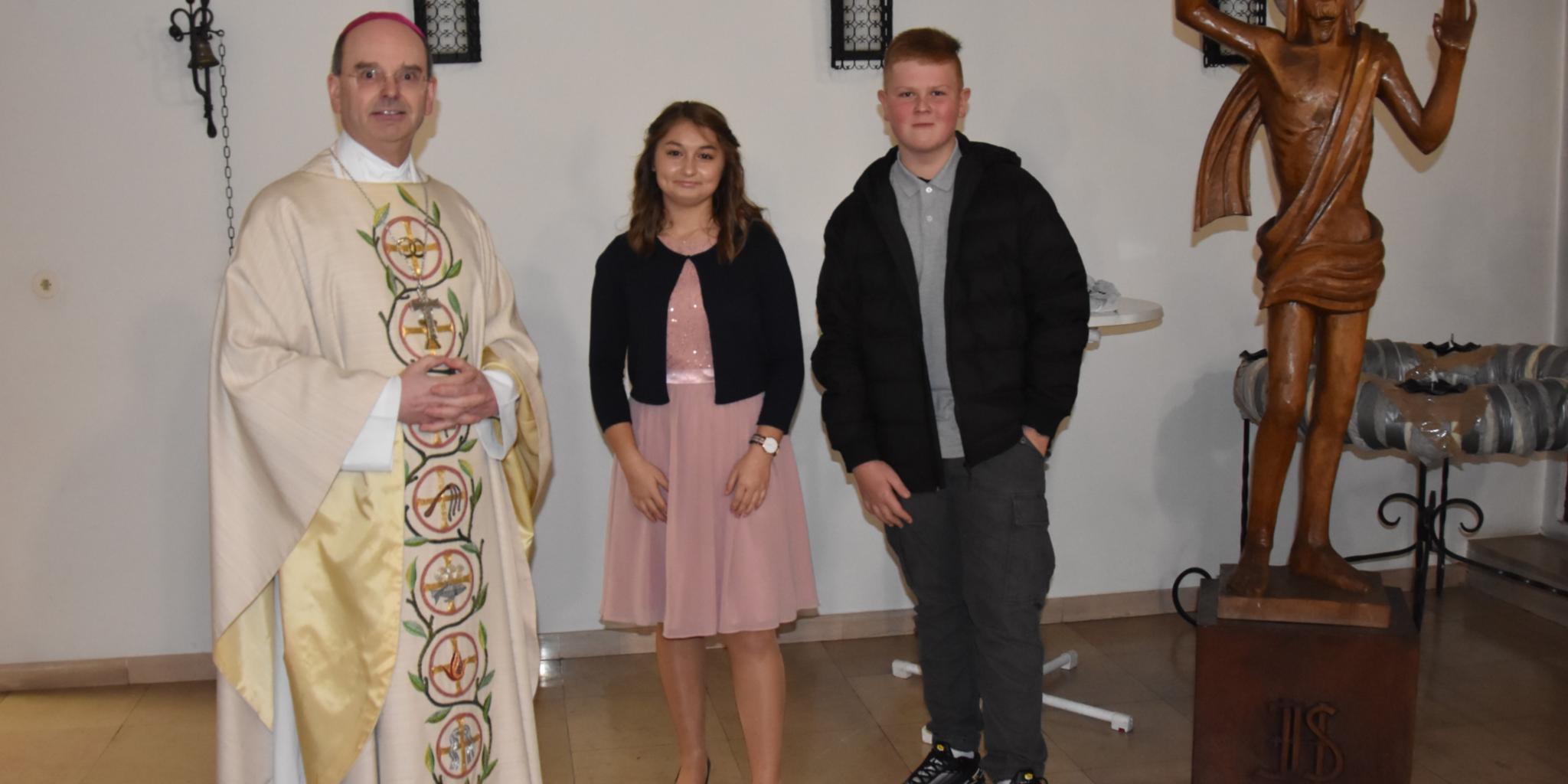 Weihbischof Robert Brahm mit den Firmbewerbern Chiara Saccà und Jonas Martin in der Pfarrkirche Herz Jesu in Wadgassen-Hostenbach am 31. Oktober 2020. Foto: Ute Kirch