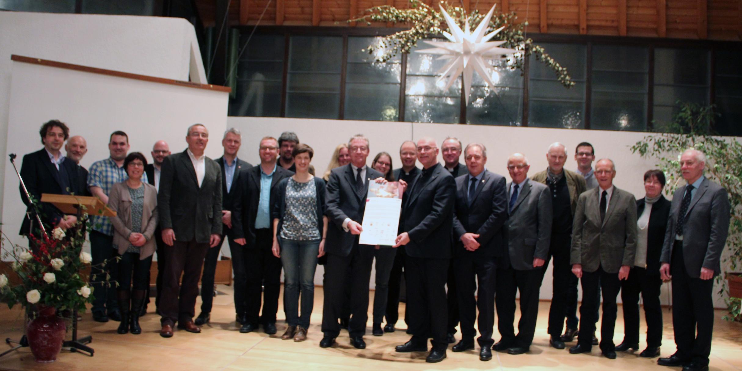 Die Projektpartner und Bischof Ackermann (mitte) mit dem unterschriebenen Leitwort.