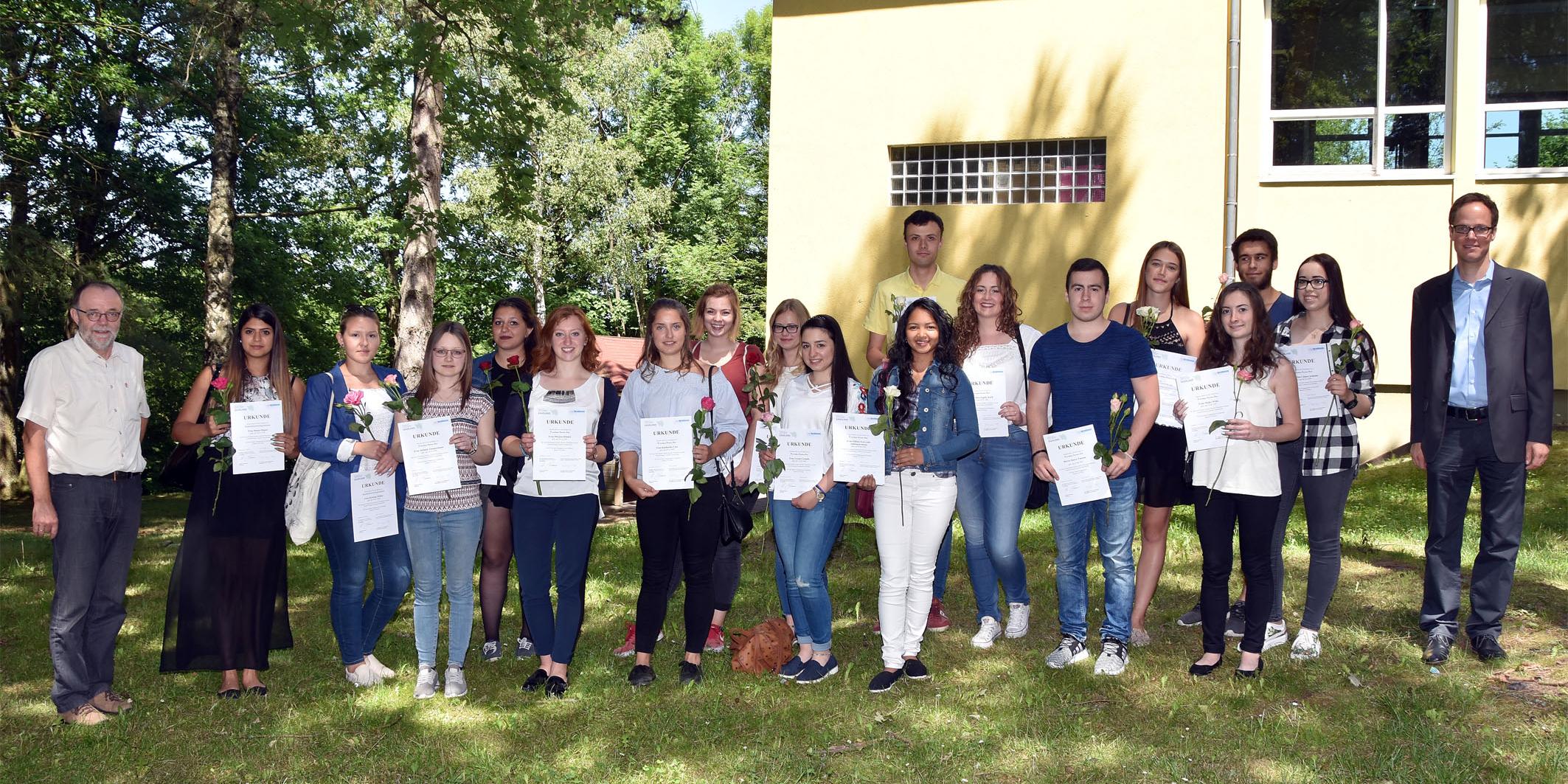 Zusammen mit Peter Nilles (l.) und Johannes Ernsdorf (r.) von den Sozialen Lerndiensten präsentieren die Freiwilligen stolz ihre Ehrungsurkunden.