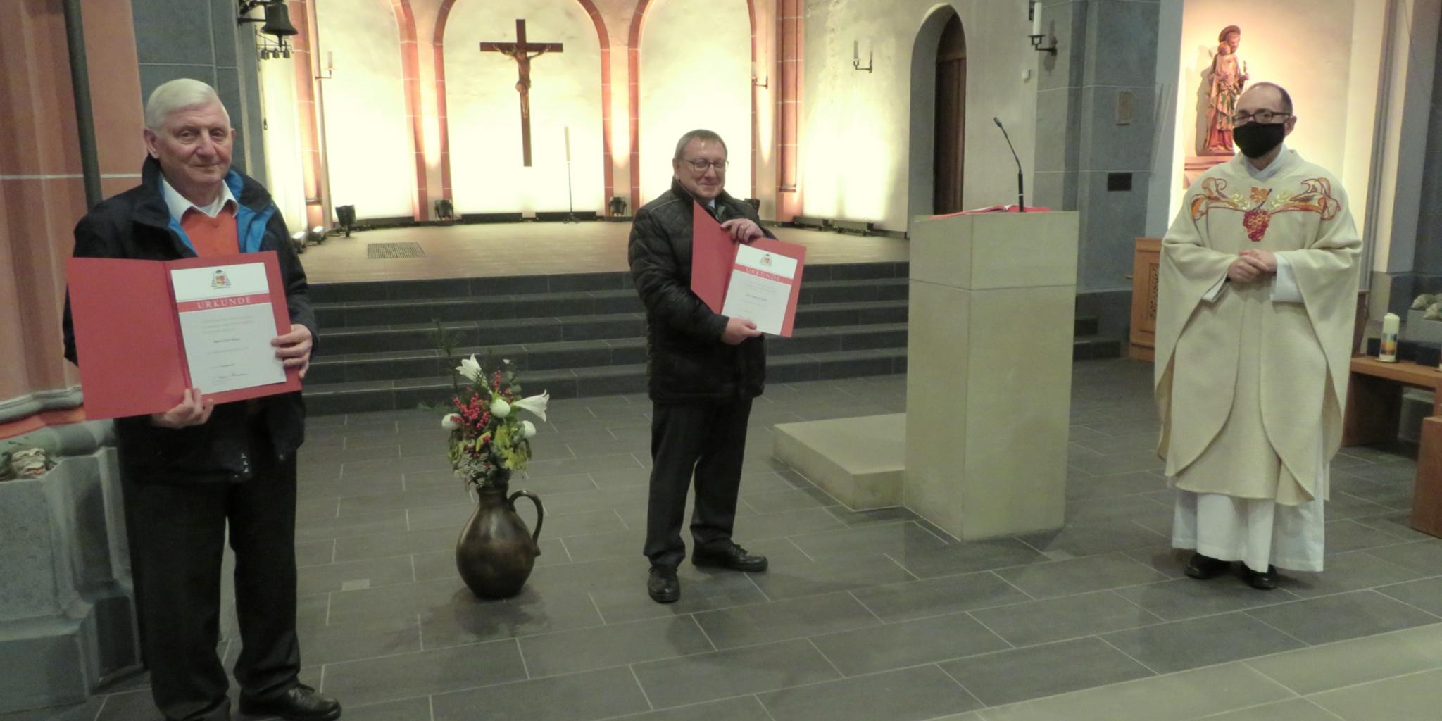 Pfarrer Augustinus Jünemann (rechts) überreicht Carl Woog (links) und Reimund Kerner die Dankesurkunde des Bistums Trier. Foto: Heinz-Walter Lautz