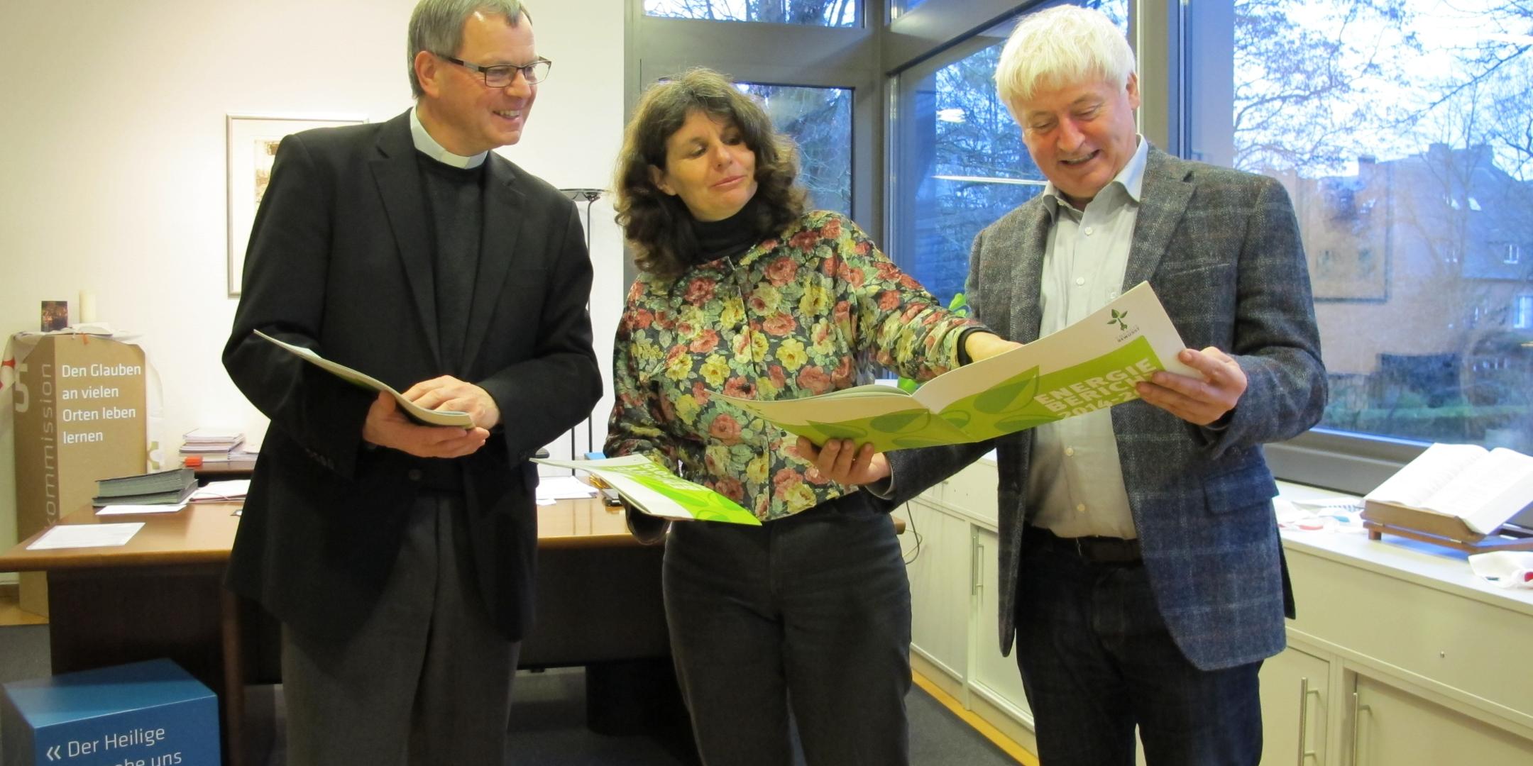 Klimamanagerin Charlotte Kleinwächter überreicht Generalvikar Dr. Ulrich Graf von Plettenberg (links) im Beisein von Dr. Gundo Lames die Energieberichte
