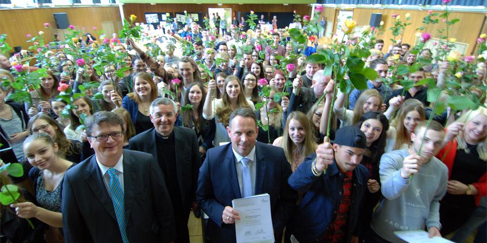 Als Zeichen der Anerkennung erhielten alle Freiwilligen eine Rose. Im Vordergrund vlnr: Hans-Josef Börsch, Prälat Franz-Josef Gebert und Staatssekretär Stephan Kolling