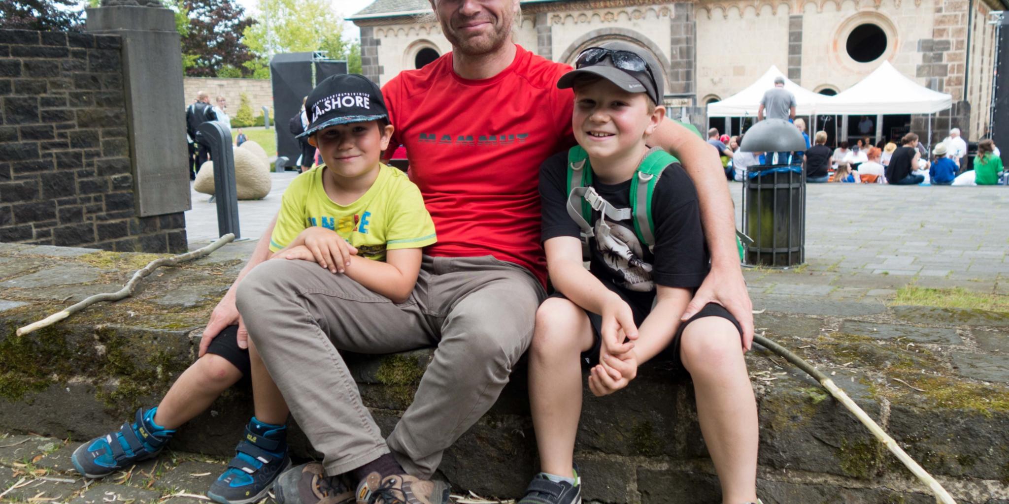 Lennard (links) und Jakob schnitzen Pilgerstäbe und werden von Papa Gerd Zimmermann unterstützt.