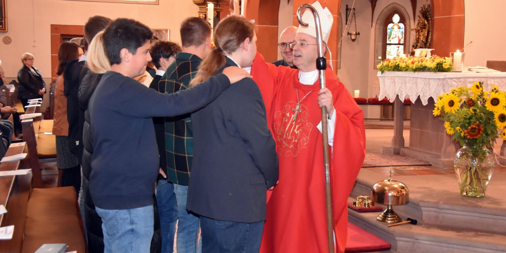 Weihbischof Robert Brahm spendet Jugendlichen das Sakrament der Firmung in der Pfarrkirche St. Willibrord in Schmelz-Limbach. Foto: Ute Kirch