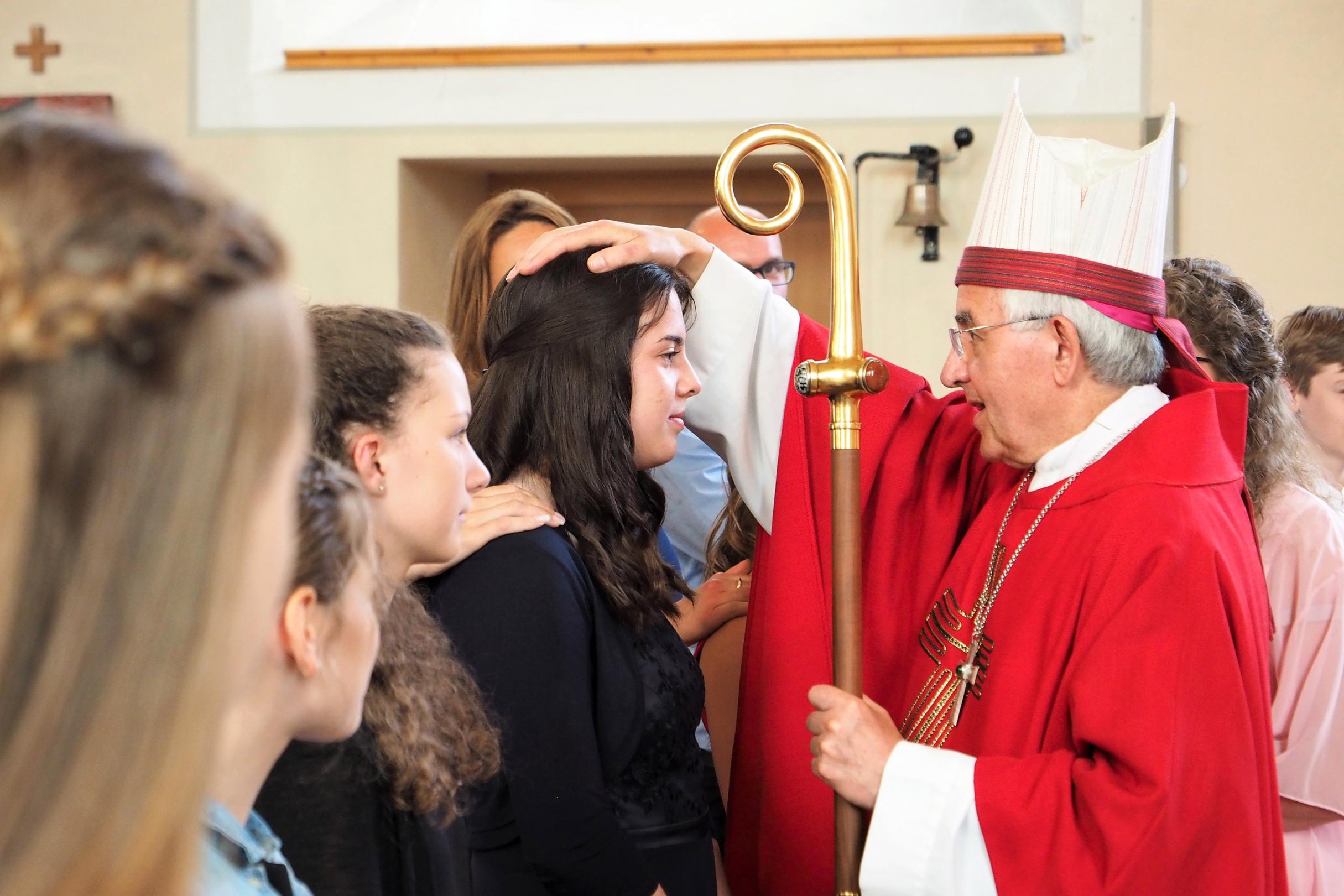 Weihbischof Gebert zeichnet mit dem Salböl, dem Chrisam, ein Kreuz auf die Stirn jedes Firmbewerbers.