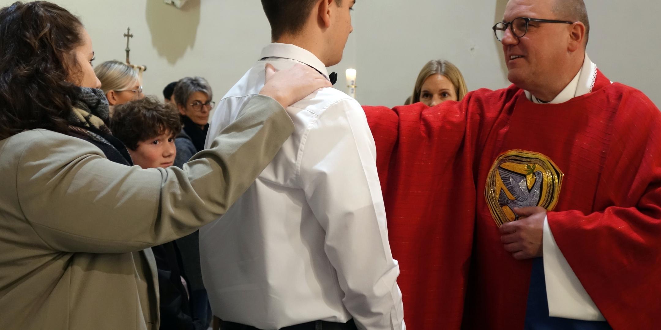 Domvikar Matthias Struth spendet einem Jugendlichen das Sakrament der Firmung (Foto: Julia Fröder/Bistum Trier)