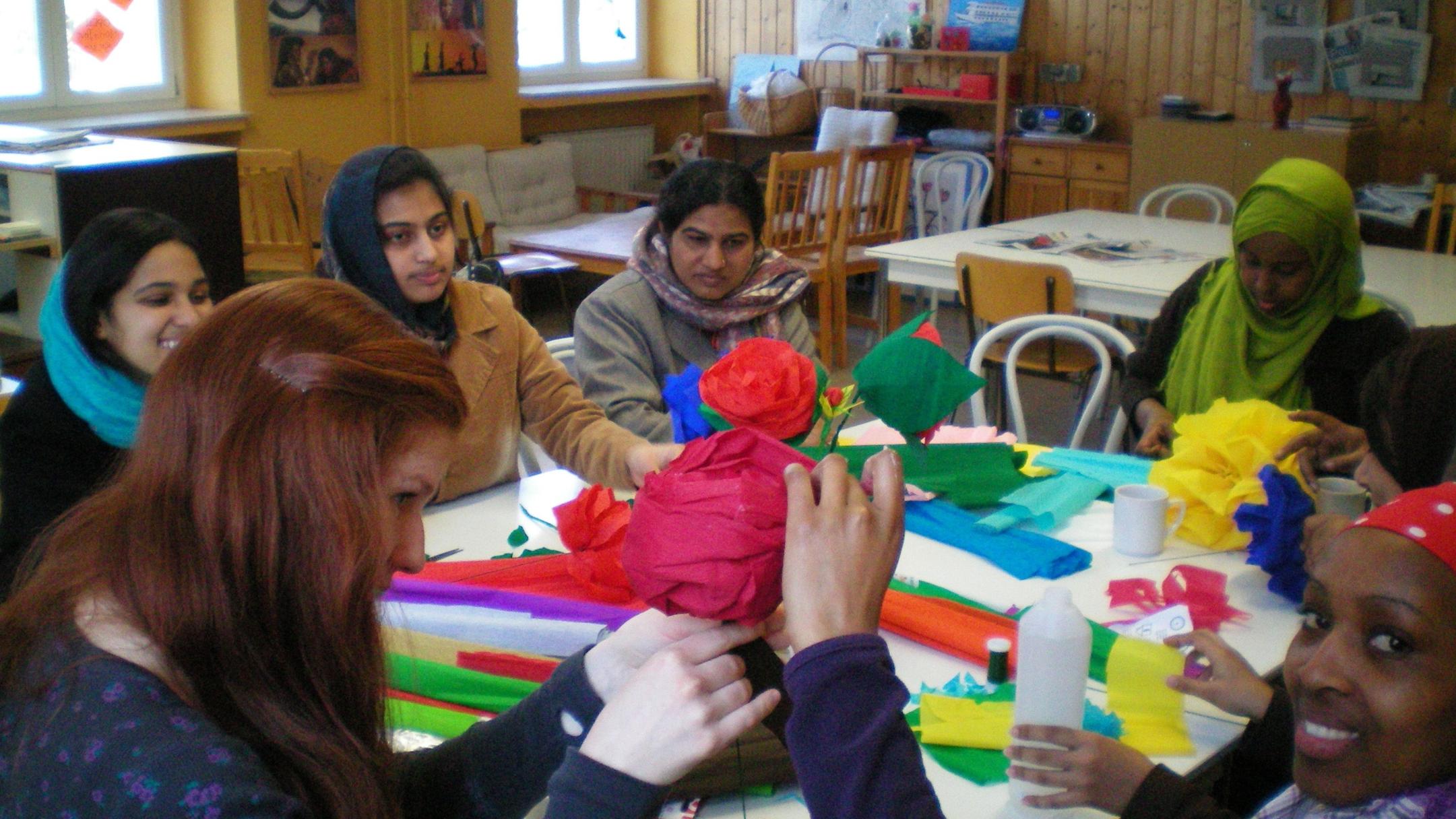 Flüchtlingsfrauen beim Basteln von Papierblumen