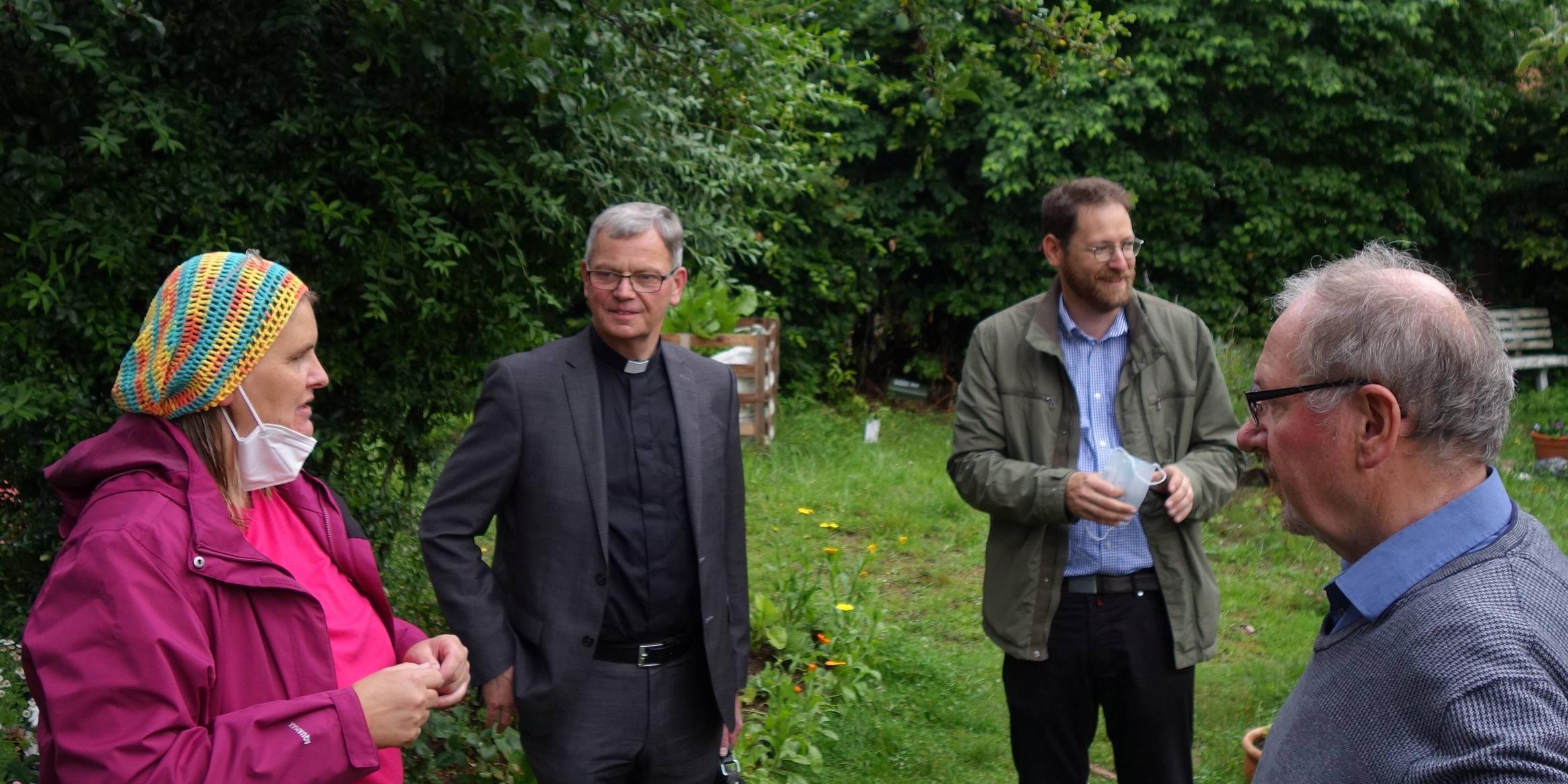 Die Ehrenamtliche Tina Monzen, Dechantenkooperator Oliver Seis (Zweiter v. rechts) und Josef Freise vom Koordinationsteam (rechts) zeigen dem Generalvikar (Zweiter v. links) die Gärten rund um Heilig Kreuz. Foto: Julia Fröder