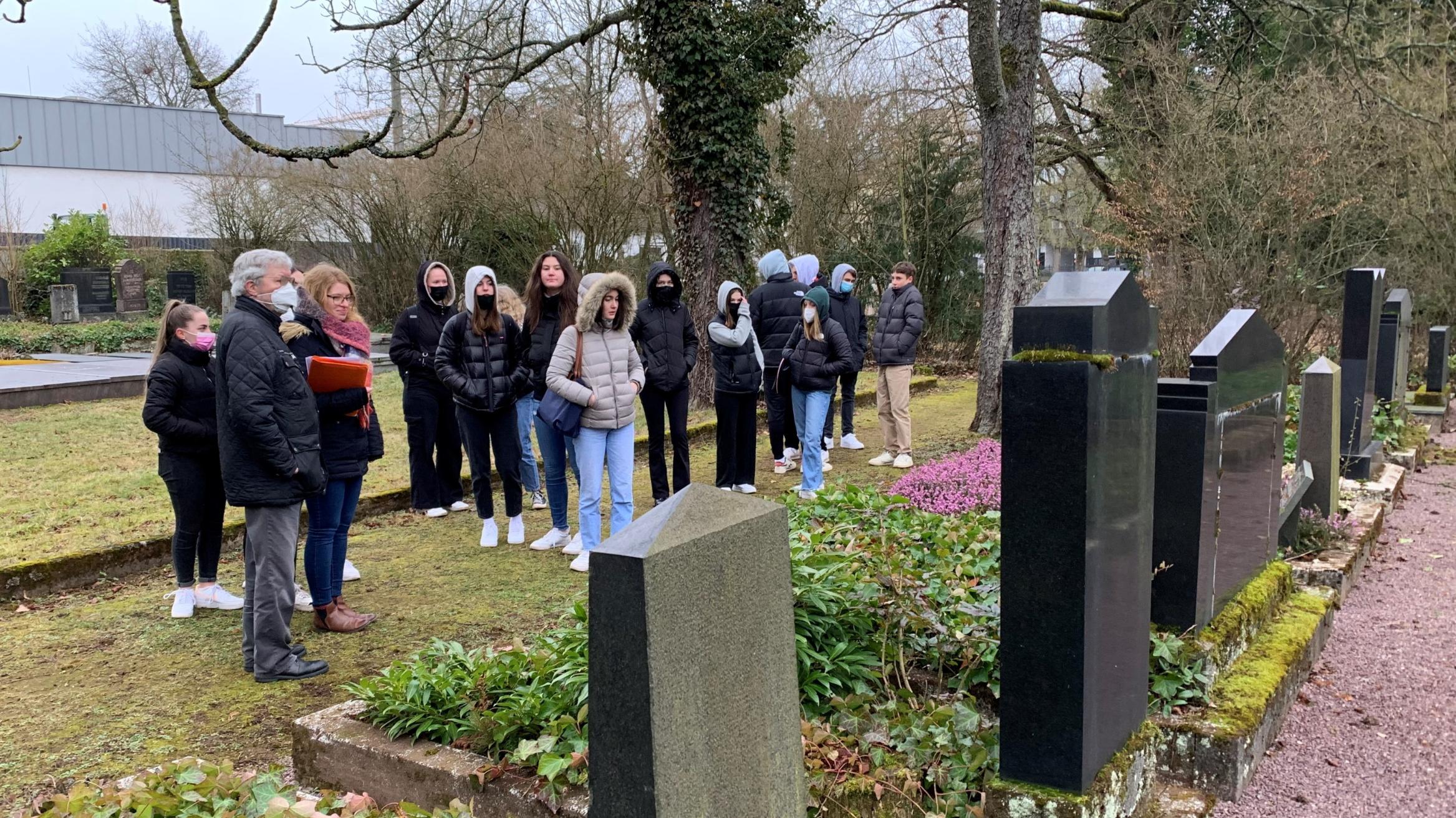 Schülerinnen und Schüler des Stadtgarten-Gymnasiums gedenken auf dem jüdischen Friedhof in Saarlouis der Opfer des Nationalsozialismus. Foto: Ute Kirch