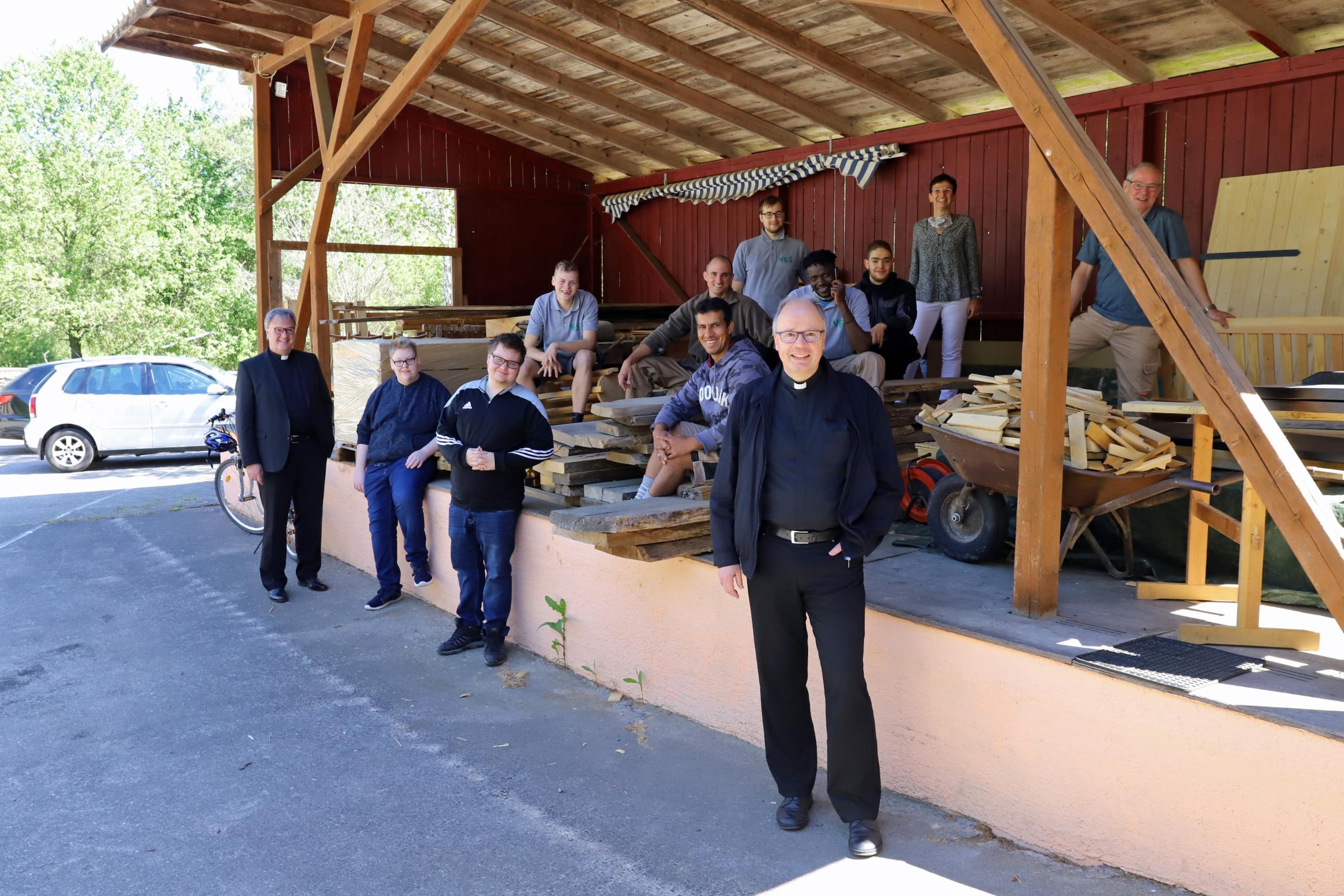 Dr. Hans Günther Ullrich (links), Andrea Steyven (zweite von rechts) und Bischof Ackermann (vorne) mit dem Team der Ausbildungswerkstatt.