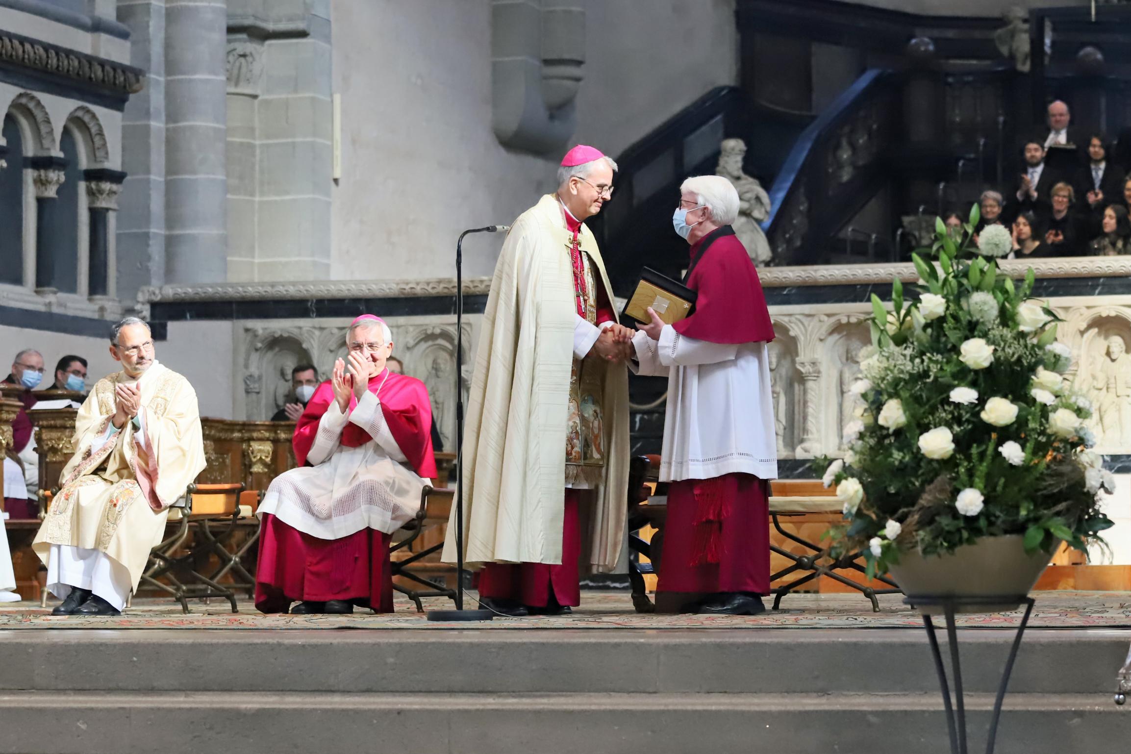 Weihbischof Peters überreicht dem nun emeritierten Dompropst das Geschenk des Domkapitels: ein Sonntagslektionar für alle drei Lesejahre mit individuell gestaltetem Einband. Foto: Judith Rupp/Bistum Trier.