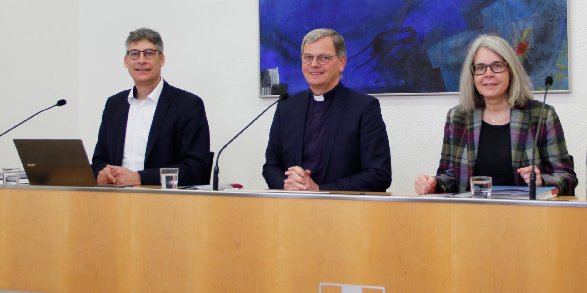 vlnr. Manfred Wagner, Leiter des Strategiebereichs „Ziele und Entwicklung“, Generalvikar Dr. Ulrich Graf von Plettenberg und Kirsten Straus, Leiterin des Zentralbereichs „Ressourcen“. Die Pressekonferenz fand unter 2G+ statt. (Foto: Christina Libeaux, Bistum Trier)