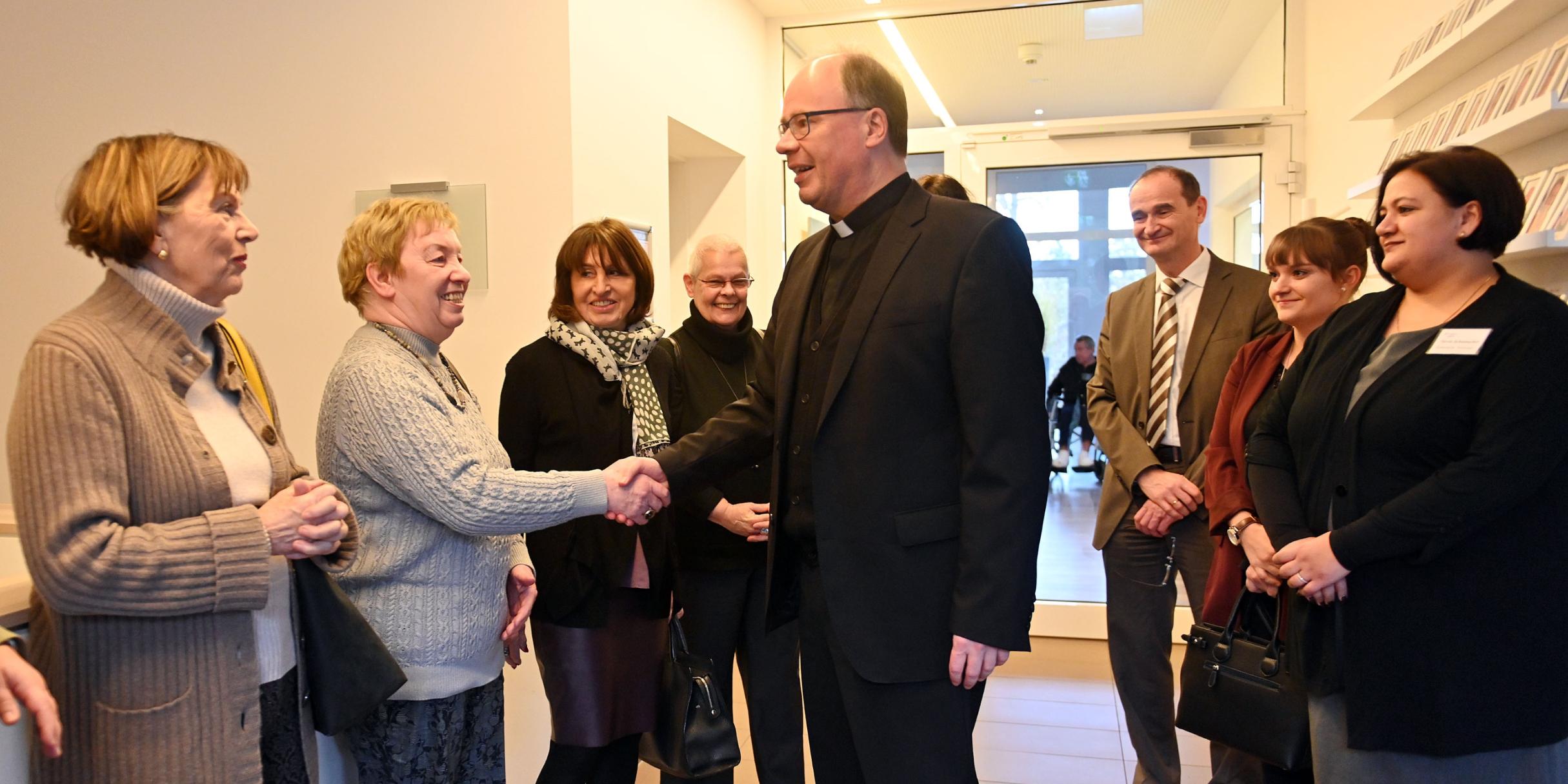Bischof Dr. Stephan Ackermann spricht mit ehren- und hauptamtlichen Mitarbeiterinnen und Mitarbeitern des Hospizes.