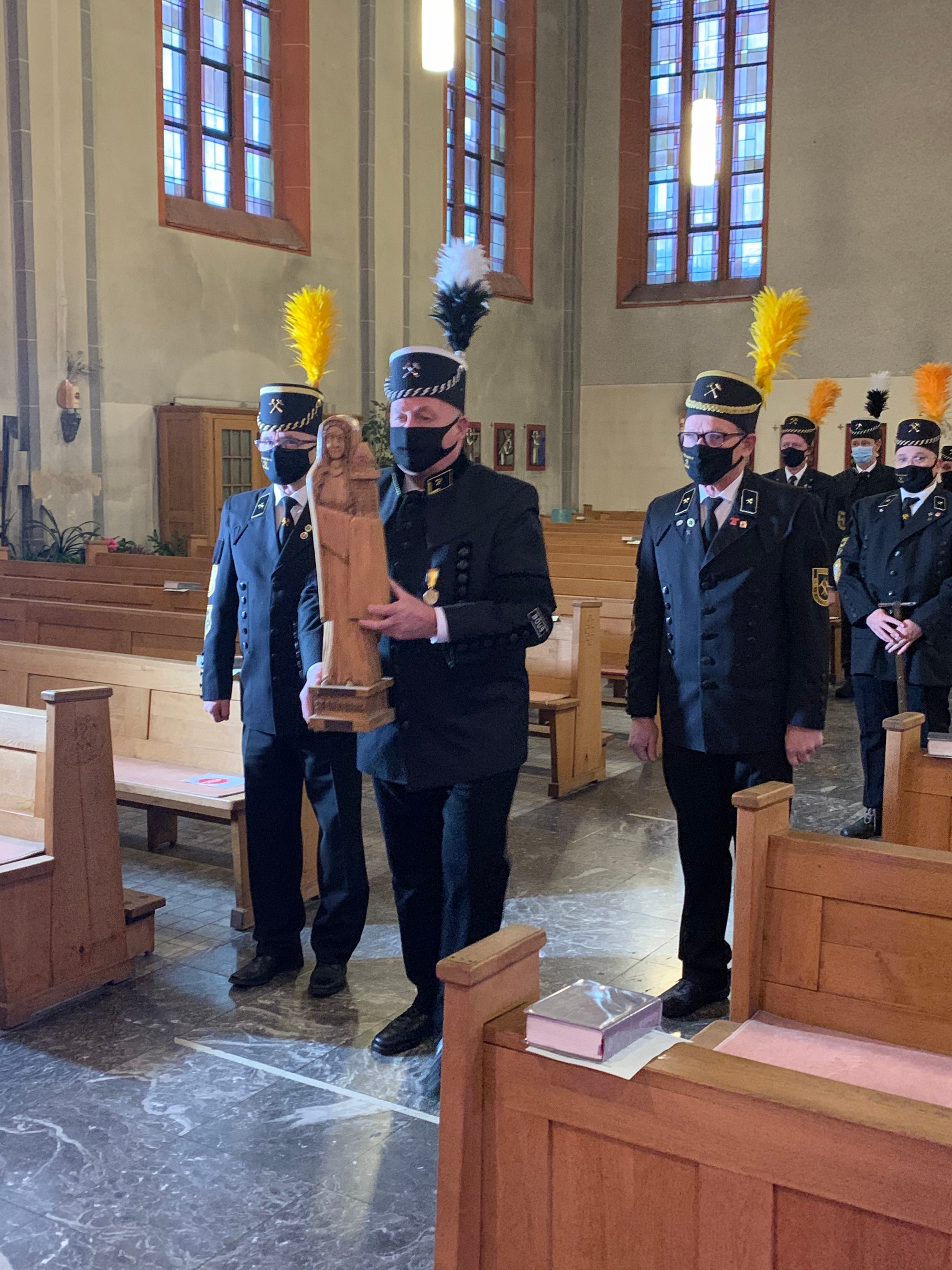 Saarländische Bergleute tragen die Statue der Heiligen Barbara beim Einzug zum Altar. Foto: uk