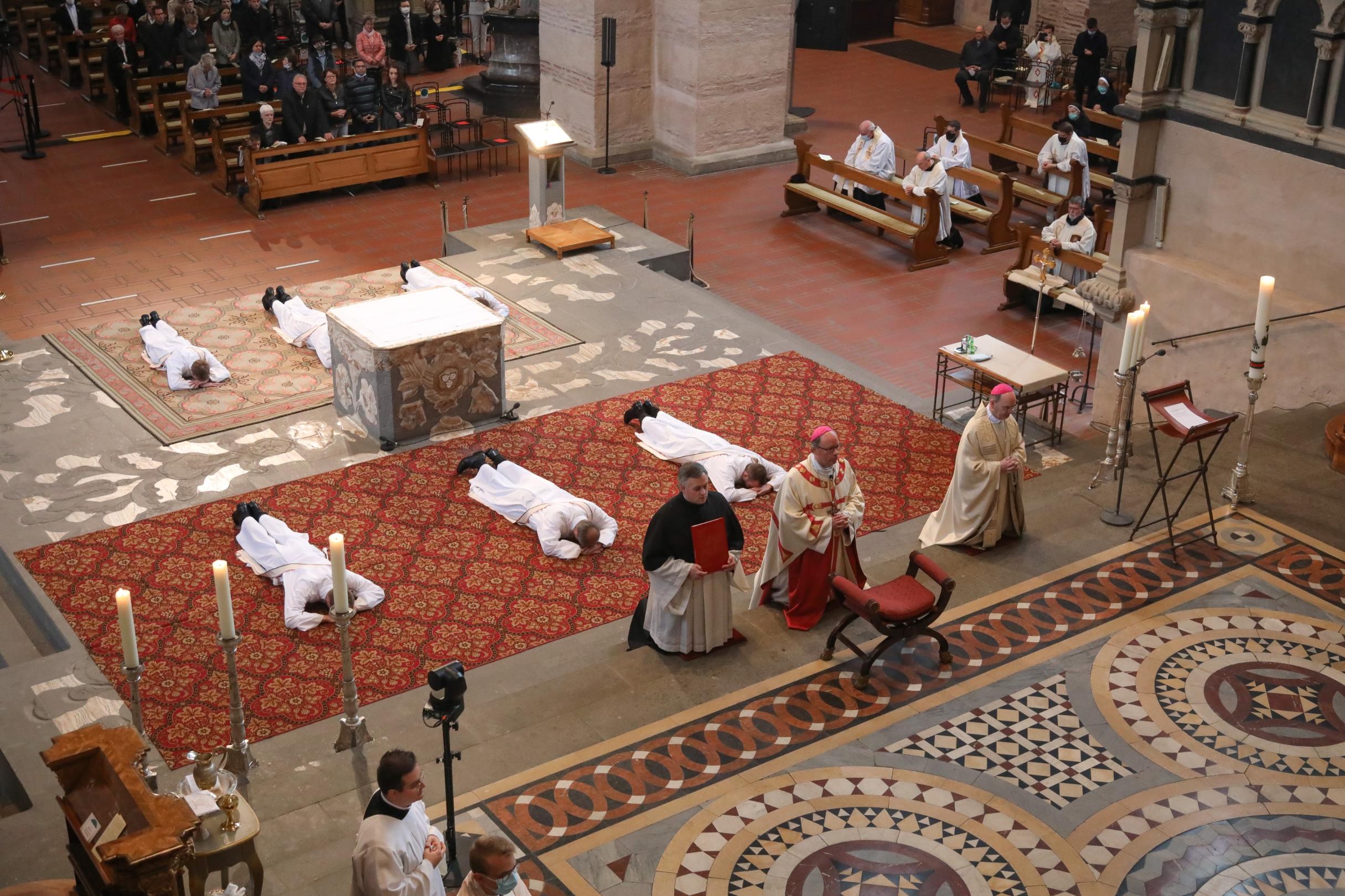 Die Weihekandidaten liegen zum Bittgebet der Allerheiligenlitanei ausgestreckt vor dem Altar - als Zeichen der Hingabe und Demut. Foto: Bistum Trier/Helmut Thewalt